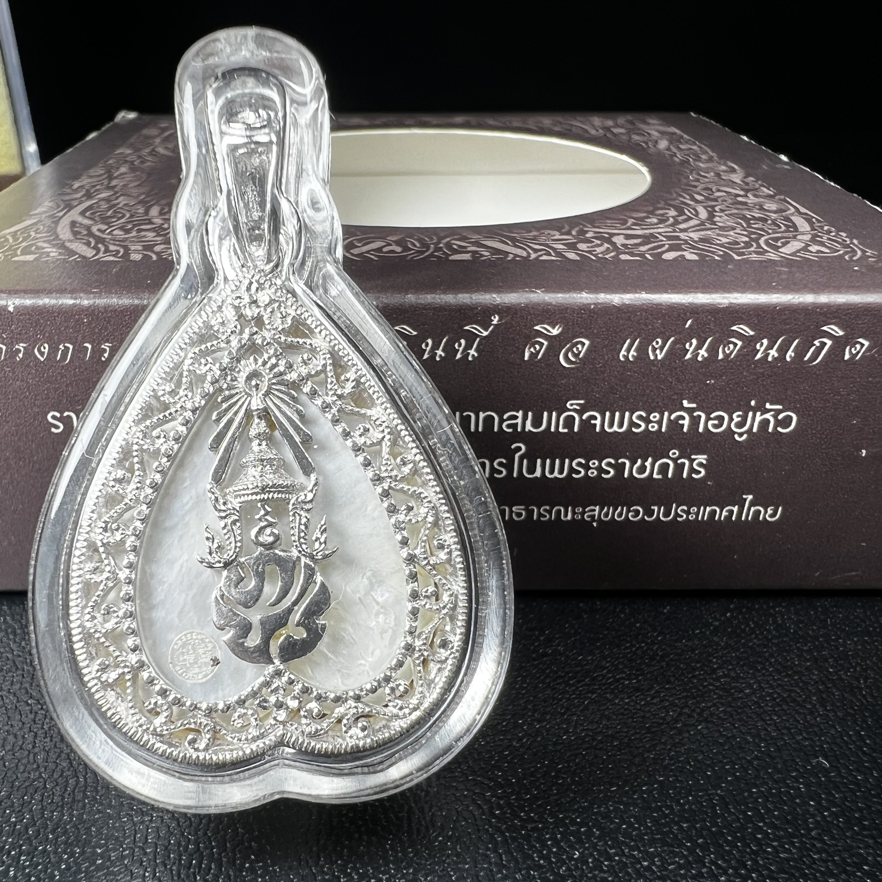 พระพุทธชินราช ภปร. โครงการ "เพราะแผ่นดินนี้ คือ แผ่นดินเกิด" ปี2548(รุ่นแรก) เหรียญทรงใบโพธิ์ ขนาด 21 x 29 มม. เนื้อเงินสามกษัตริย์ องค์พระชุบสามกษัตริย์ ล้อมด้วยกรอบเงินชุบทองคำขาวสลักเสลาเป็นลวดลายละเอียดอ่อน ส่วนพื้นองค์พระเป็นเปลือกหอยมุข