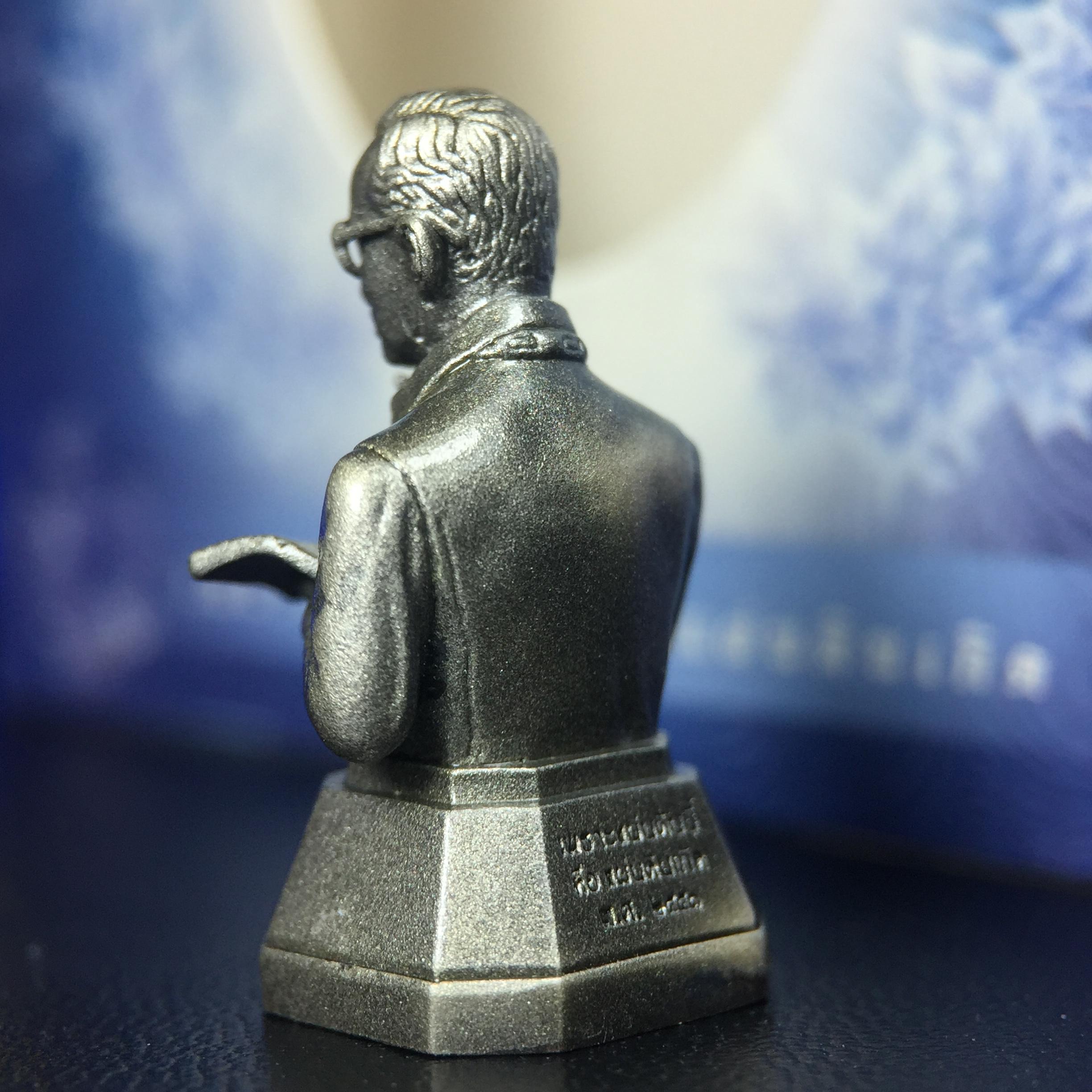 พระบรมรูปพระบาทสมเด็จพระเจ้าอยู่หัวรัชกาลที่ 9(ทรงงาน) ภปร. รุ่นเพราะแผ่นดินนี้คือแผ่นดินเกิด ปี 2551 ขนาดสูง 1 นิ้ว เนื้อบรอนซ์ชุบเงินรมดำ(ด้านหน้า ฐานพระบรมรูปฯ ประดิษฐานอักษรพระปรมาภิไธย ภ.ป.ร.)นิยมหายาก