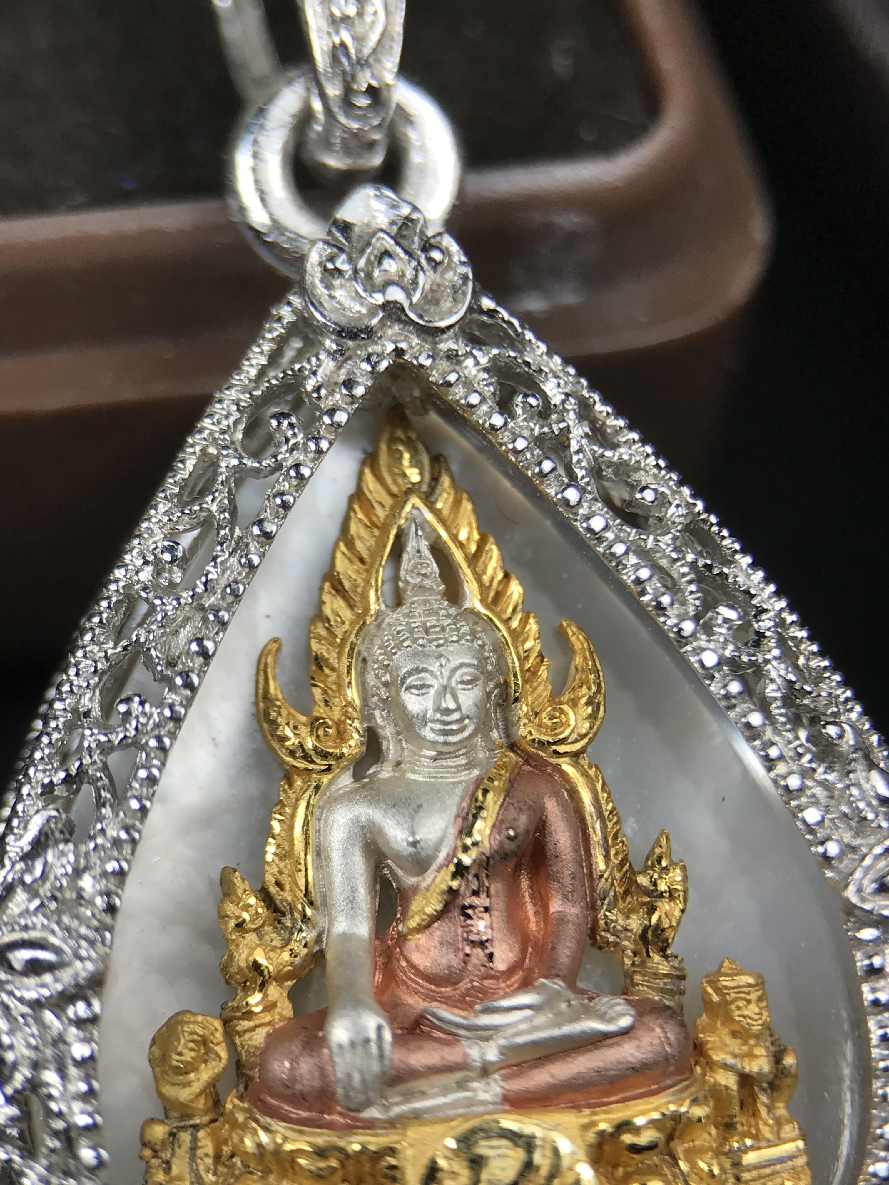 พระพุทธชินราช ภปร. โครงการ "เพราะแผ่นดินนี้ คือ แผ่นดินเกิด" ปี 2548(รุ่นแรก) เหรียญทรงหยดน้ำ ขนาด 21 x 31 มม. เนื้อเงินสามกษัตริย์ องค์พระชุบสามกษัตริย์ ล้อมด้วยกรอบเงินชุบทองคำขาวสลักเสลาเป็นลวดลายละเอียดอ่อน ส่วนพื้นองค์พระเป็นเปลือกหอยมุข