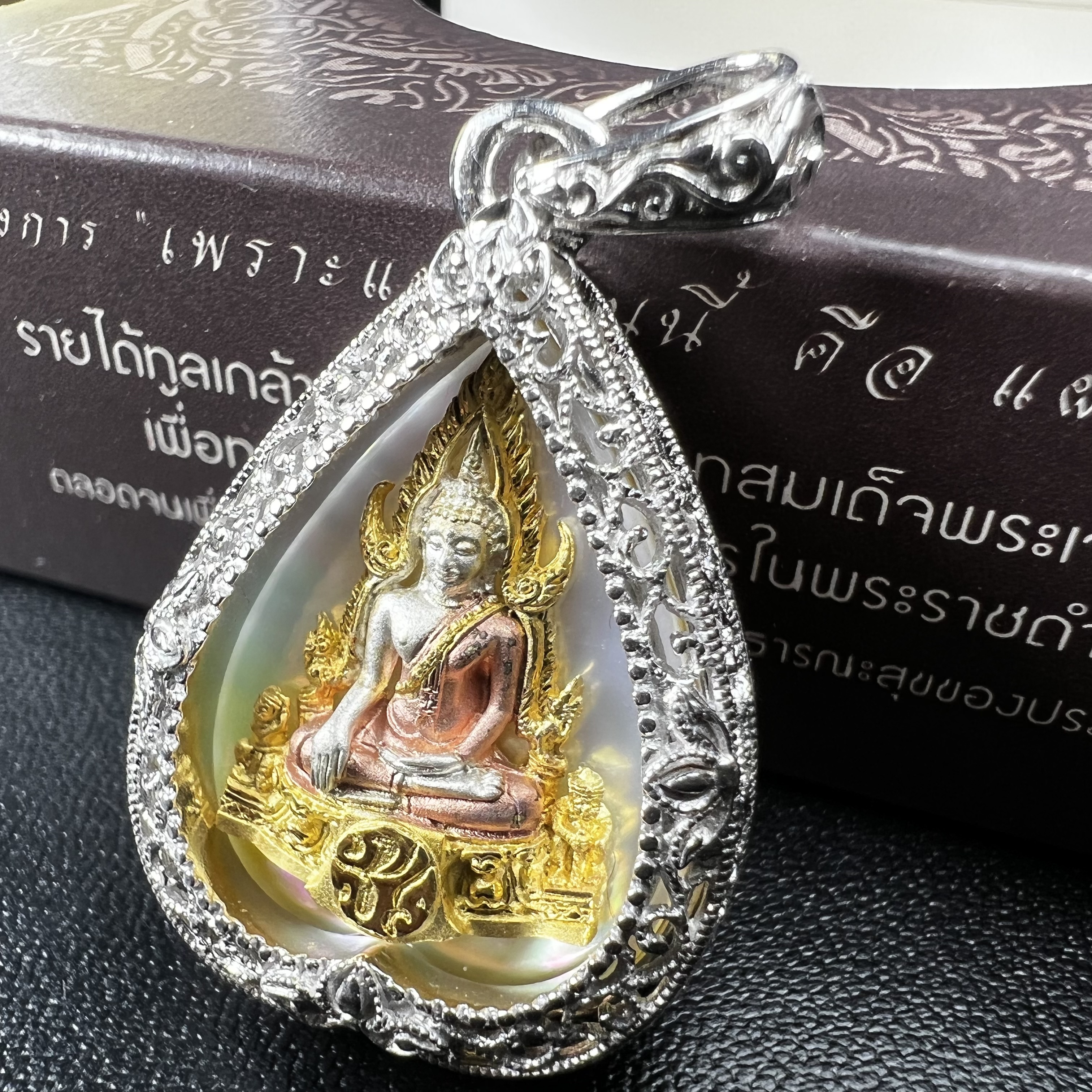 พระพุทธชินราช ภปร. โครงการ "เพราะแผ่นดินนี้ คือ แผ่นดินเกิด" ปี2548(รุ่นแรก) เหรียญทรงใบโพธิ์ ขนาด 21 x 29 มม. เนื้อเงินสามกษัตริย์ องค์พระชุบสามกษัตริย์ ล้อมด้วยกรอบเงินชุบทองคำขาวสลักเสลาเป็นลวดลายละเอียดอ่อน ส่วนพื้นองค์พระเป็นเปลือกหอยมุข