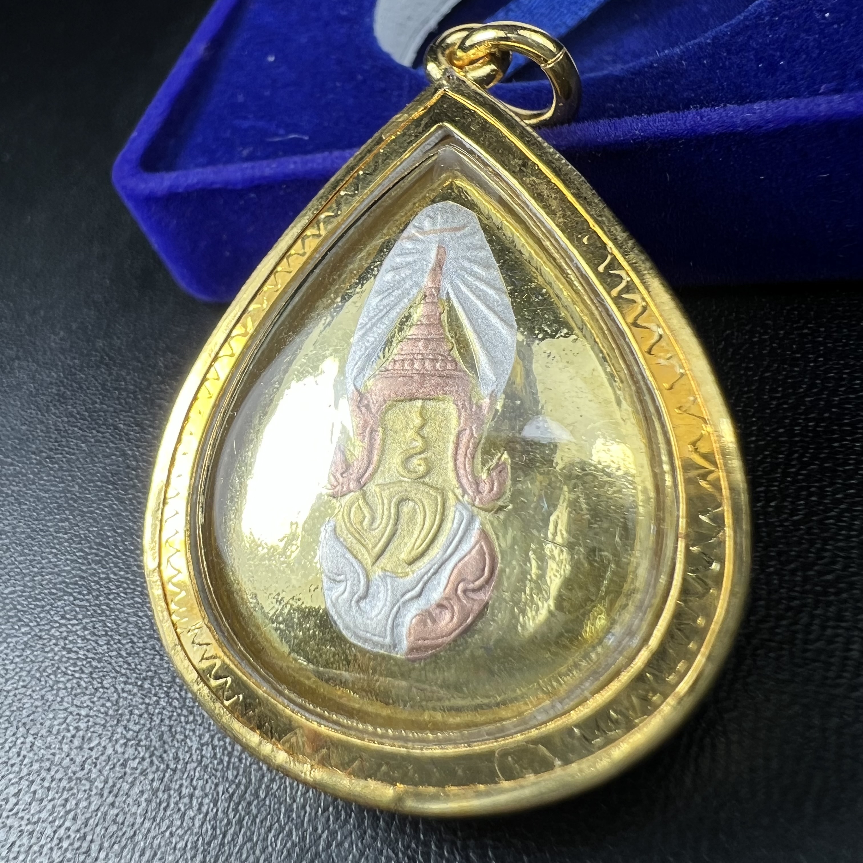 เหรียญพระพุทธสิงหธรรมมงคล ภปร. ปี 2547 ทรงหยดน้ำ ด้านหลังมี ภ.ป.ร. (ชนวนเก่า)เนื้อโลหะผสม ชุบทองสามกษัตริย์ สูง 3.3ซม.พิธีใหญ่ มวลสารดี ปลุกเสกวัดพระแก้ว(งานเลี่ยมกรอบเดิมจากผู้จัดสร้างห่อหุ้มด้วยทองนพเกล้า)