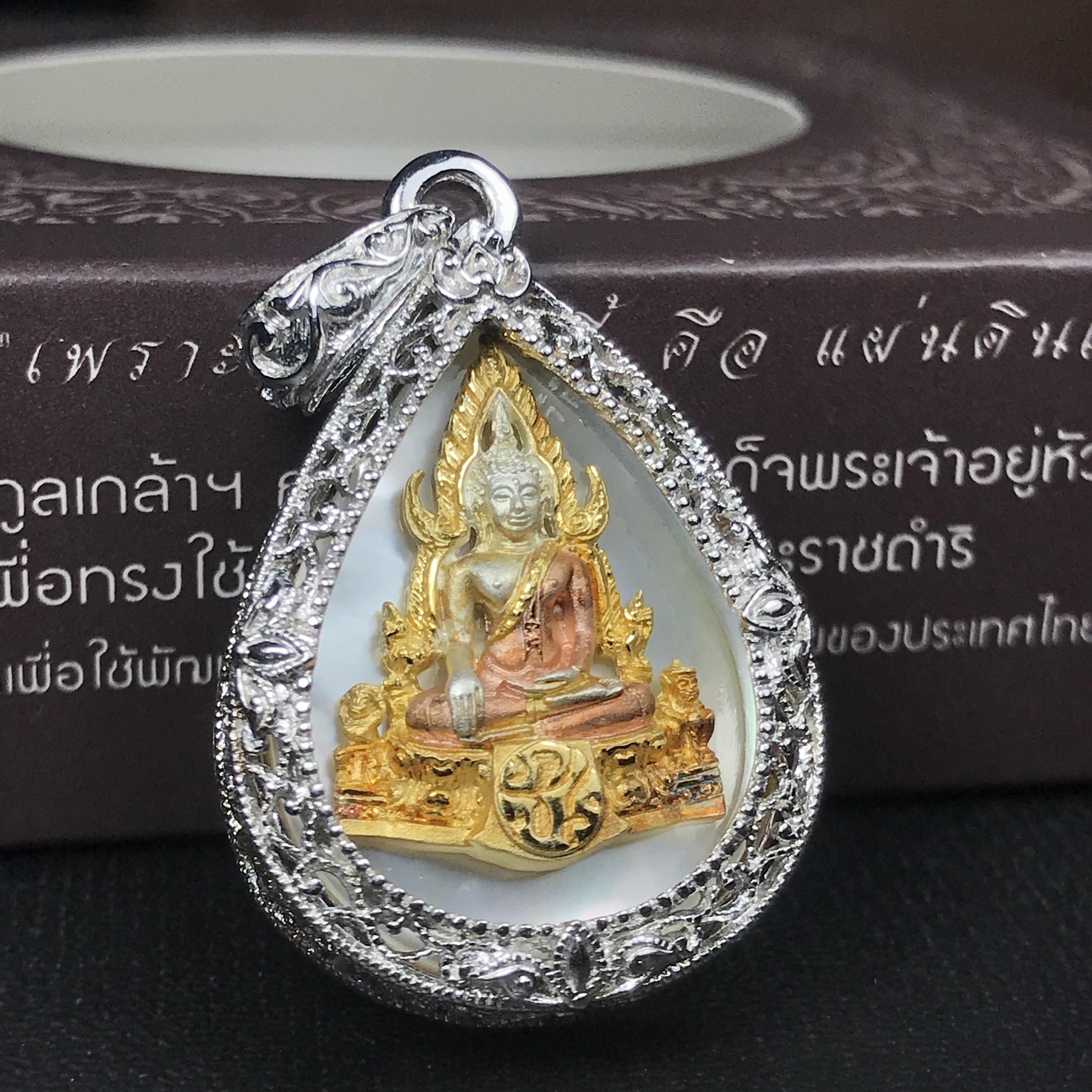 พระพุทธชินราช ภปร. โครงการ "เพราะแผ่นดินนี้ คือ แผ่นดินเกิด" ปี2548(รุ่นแรก) เหรียญทรงหยดน้ำ ขนาด 21 x 31 มม. เนื้อเงินสามกษัตริย์ องค์พระชุบสามกษัตริย์ ล้อมด้วยกรอบเงินชุบทองคำขาวสลักเสลาเป็นลวดลายละเอียดอ่อน ส่วนพื้นองค์พระเป็นเปลือกหอยมุข