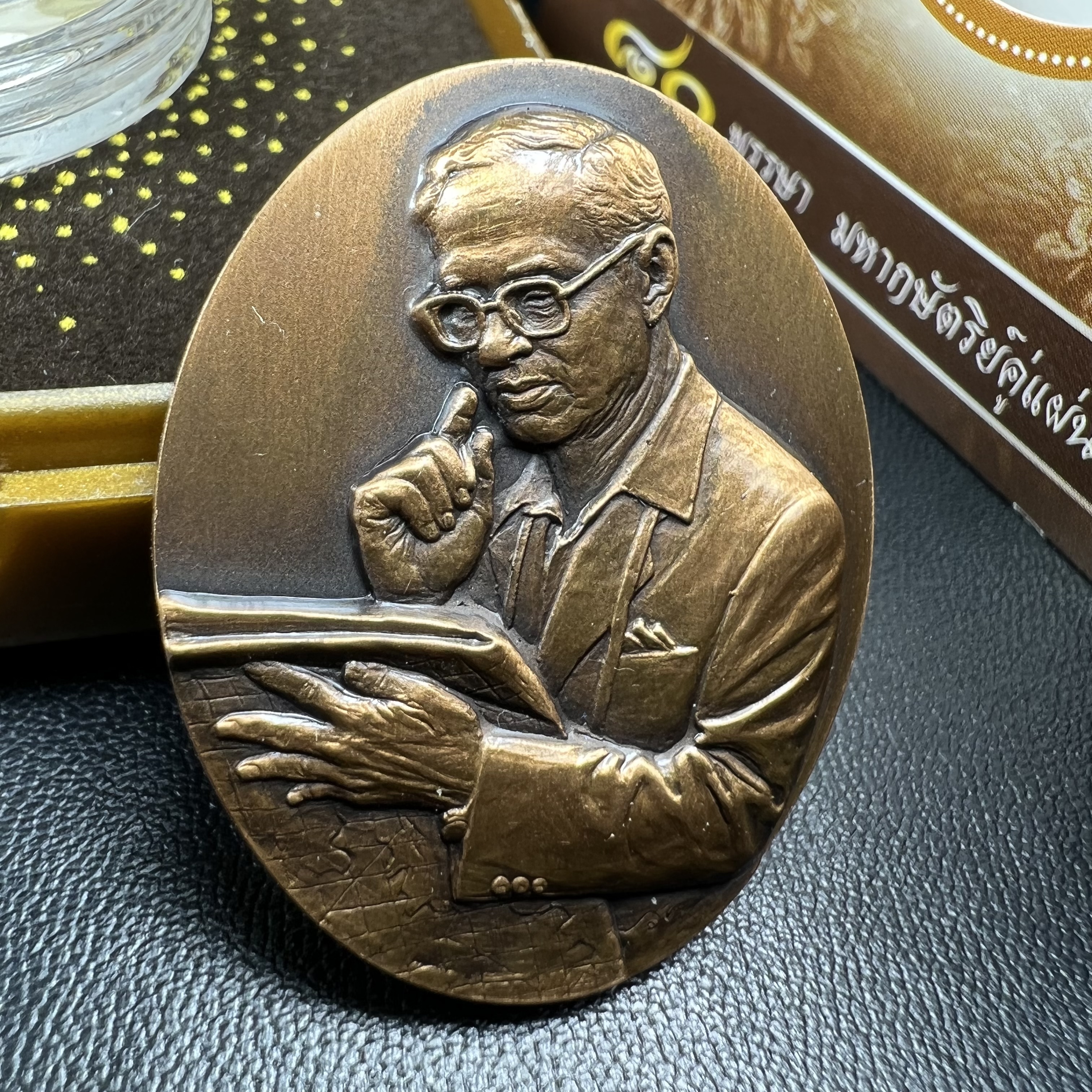 เหรียญรูปหล่อพระบาทสมเด็จพระเจ้าอยู่หัว ในหลวงทรงงาน “รุ่นเย็นศิระเพราะพระบริบาล 80พรรษา มหากษัตริย์คู่แผ่นดินสยาม” พ.ศ.2550 เนื้อทองแดงรมดำ(ขนาด 27*35 มม.)พร้อมกล่องบรรจุเดิมครบ