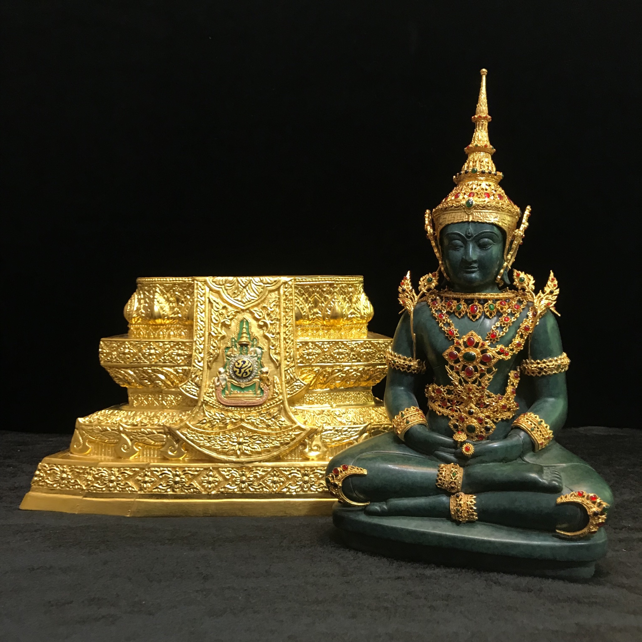 พระแก้วมรกต(จำลอง)ลอยองค์ ขนาดหน้าตัก 5 นิ้ว ทรงเครื่องฤดูร้อน เนื้อโลหะเคลือบสีเขียว เครื่องทรงชุบทองลงยาสี ฐานเนื้อโลหะ ลงรักปิดทองคำ ประดิษฐานตราสัญลักษณ์ฉลองสิริราชสมบัติ ครบ 60 ปี