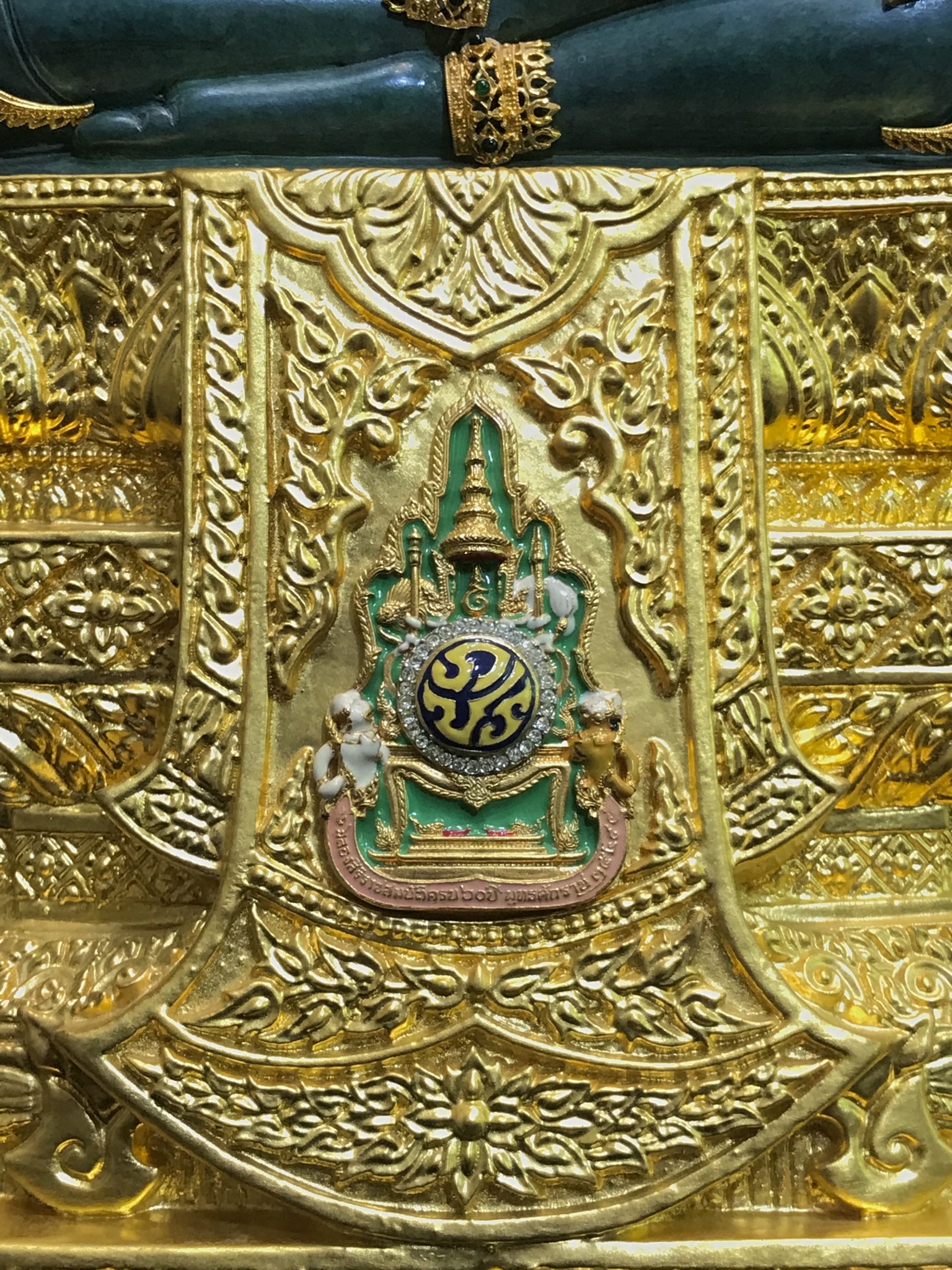 พระแก้วมรกต(จำลอง)ลอยองค์ ขนาดหน้าตัก 5 นิ้ว ทรงเครื่องฤดูร้อน เนื้อโลหะเคลือบสีเขียว เครื่องทรงชุบทองลงยาสี ฐานเนื้อโลหะ ลงรักปิดทองคำ ประดิษฐานตราสัญลักษณ์ฉลองสิริราชสมบัติ ครบ 60 ปี