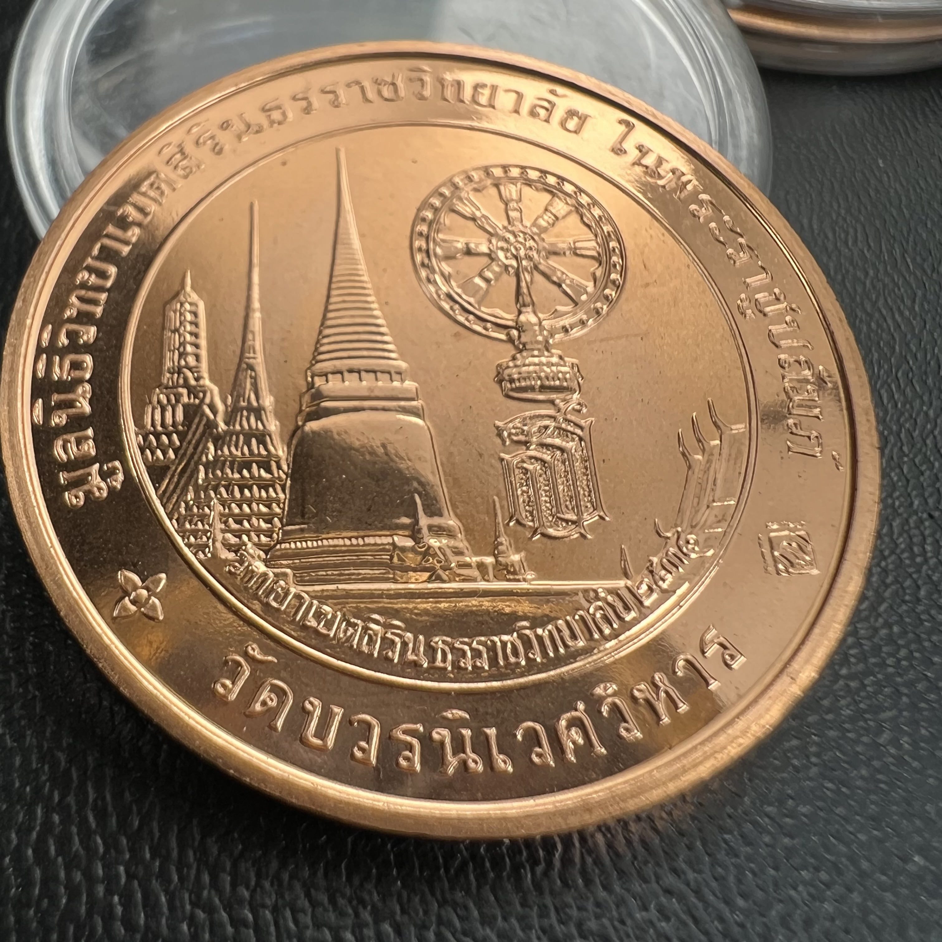 เหรียญพระแก้วมรกต ทรงเครื่องฤดูหนาว หลัง สธ.รุ่นเฉลิมพระเกียรติ ออกโดยมูลนิธิวิทยาเขตสิรินธรราชวิทยาลัย ในพระบรมราชูปถัมภ์ วัดบวรนิเวศวิหาร ปี 2538 เนื้อทองแดงบริสุทธิ์ 99.50% ขัดเงาสามมิติ ขนาด 3.2 ซม.ผลิตโดยโรงกษาปณ์ POB JOY MINT LTD.UK ประเทศอังกฤษ(เหร