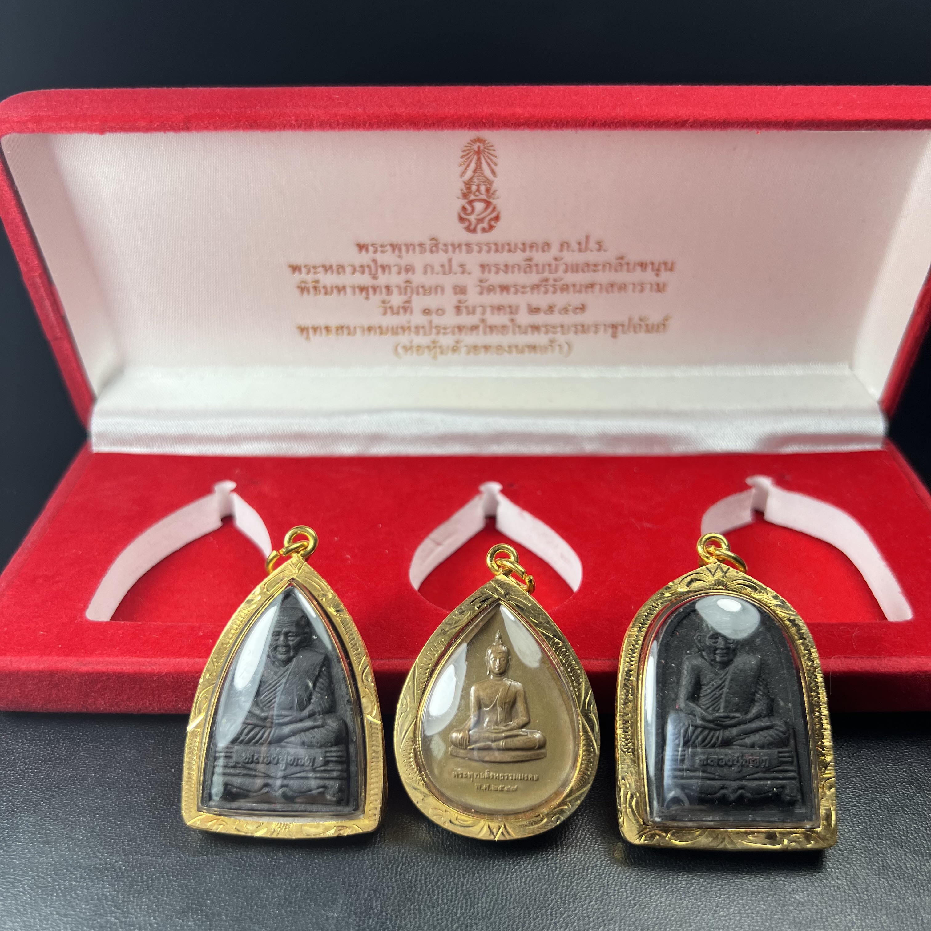 พระชุดของขวัญ 3 องค์ พระหลวงปู่ทวด ภปร. ทรงกลีบบัวและกลีบขนุนพร้อมเหรียญพระพุทธสิงหธรรมมงคล ปี 2547 (ชนวนเก่า)เนื้อว่านด้านหลังมี ภปร. เป็นโลหะผสมสูง 3.3ซม.พิธีใหญ่ มวลสารดี ปลุกเสกวัดพระแก้ว(งานเลี่ยมกรอบเดิมจากผู้จัดสร้างห่อหุ้มด้วยทองนพเกล้า)