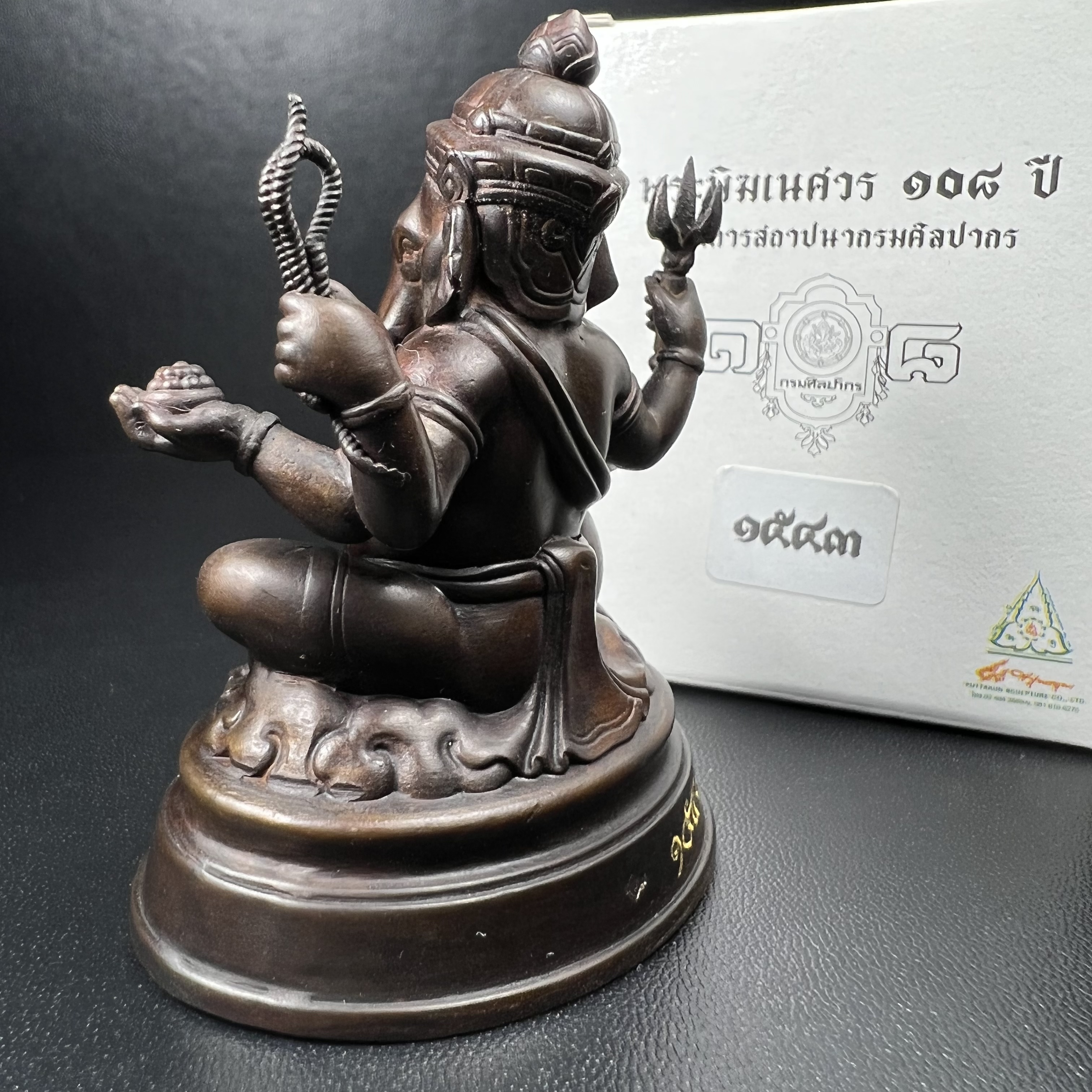 พระพิฆเนศวร รุ่น 108 ปี แห่งการสถาปนากรมศิลปากร ปี 2562 ขนาดบูชาหน้าตัก 1.5 นิ้ว เนื้อทองเหลืองรมดำ (พิธีใหญ่ มวลสารดี)(เลขนัมเบอร์ 1543)1 ใน 1999 องค์