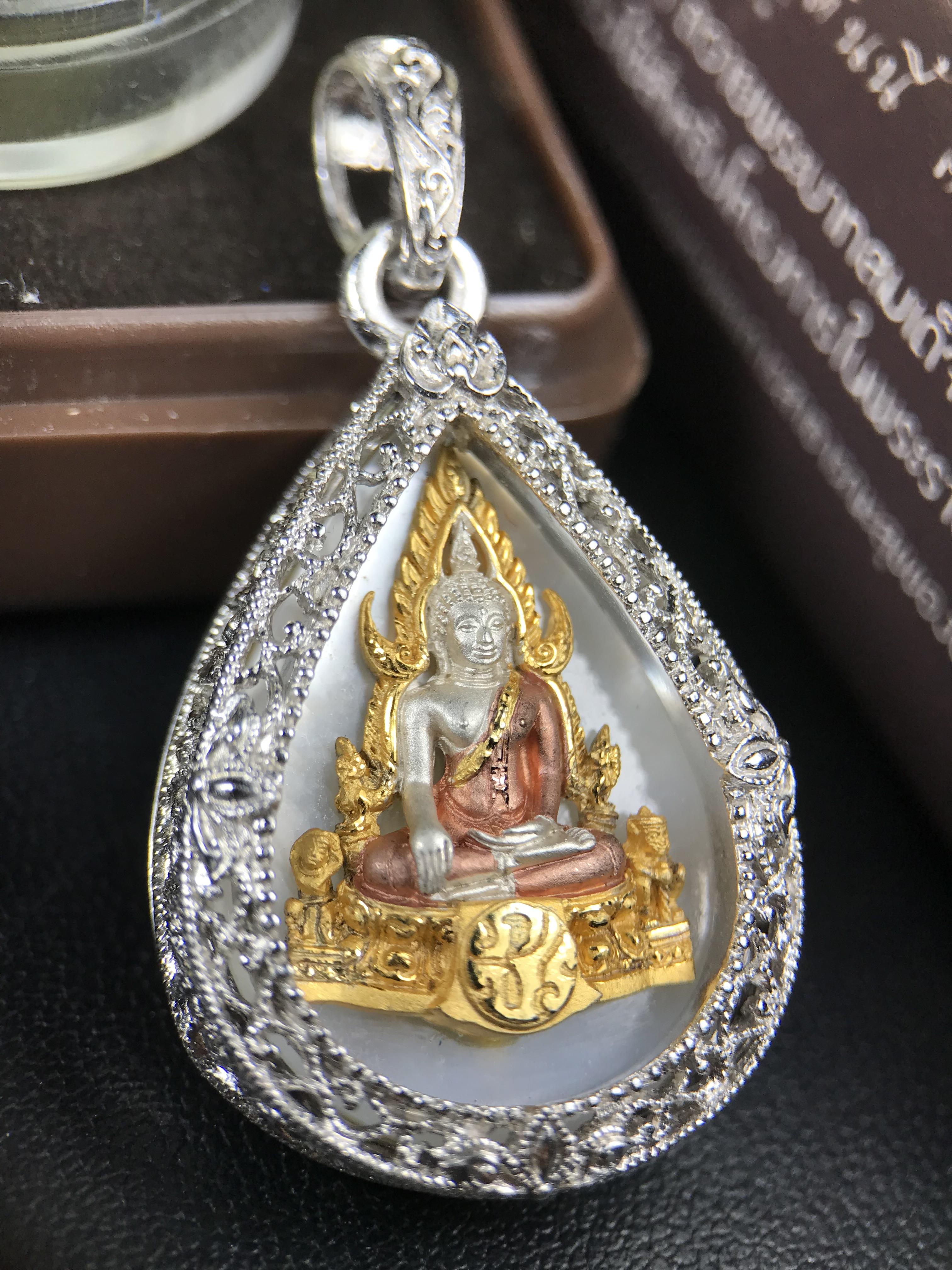 พระพุทธชินราช ภปร. โครงการ "เพราะแผ่นดินนี้ คือ แผ่นดินเกิด" ปี 2548(รุ่นแรก) เหรียญทรงหยดน้ำ ขนาด 21 x 31 มม. เนื้อเงินสามกษัตริย์ องค์พระชุบสามกษัตริย์ ล้อมด้วยกรอบเงินชุบทองคำขาวสลักเสลาเป็นลวดลายละเอียดอ่อน ส่วนพื้นองค์พระเป็นเปลือกหอยมุข