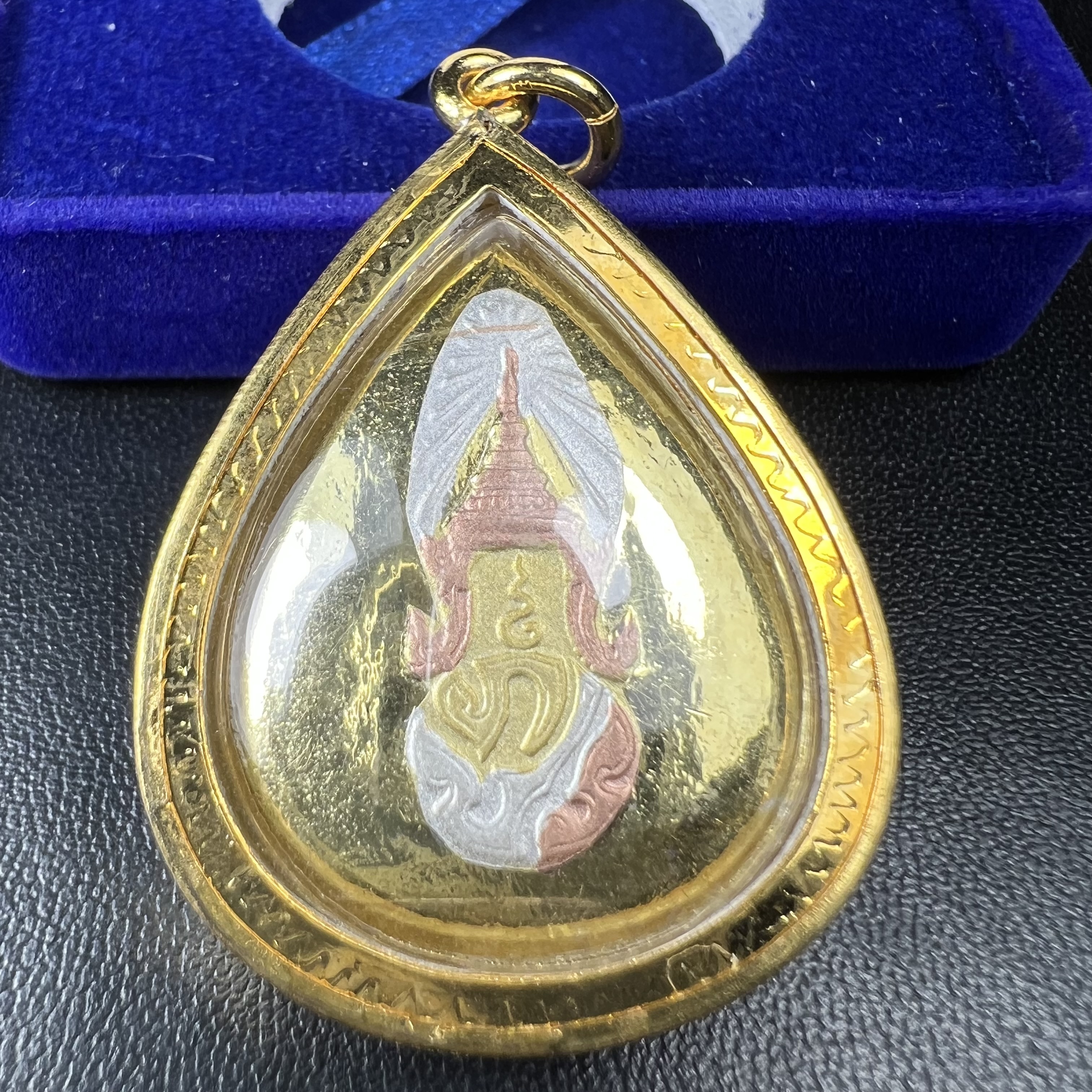 เหรียญพระพุทธสิงหธรรมมงคล ภปร. ปี 2547 ทรงหยดน้ำ ด้านหลังมี ภ.ป.ร. (ชนวนเก่า)เนื้อโลหะผสม ชุบทองสามกษัตริย์ สูง 3.3ซม.พิธีใหญ่ มวลสารดี ปลุกเสกวัดพระแก้ว(งานเลี่ยมกรอบเดิมจากผู้จัดสร้างห่อหุ้มด้วยทองนพเกล้า)