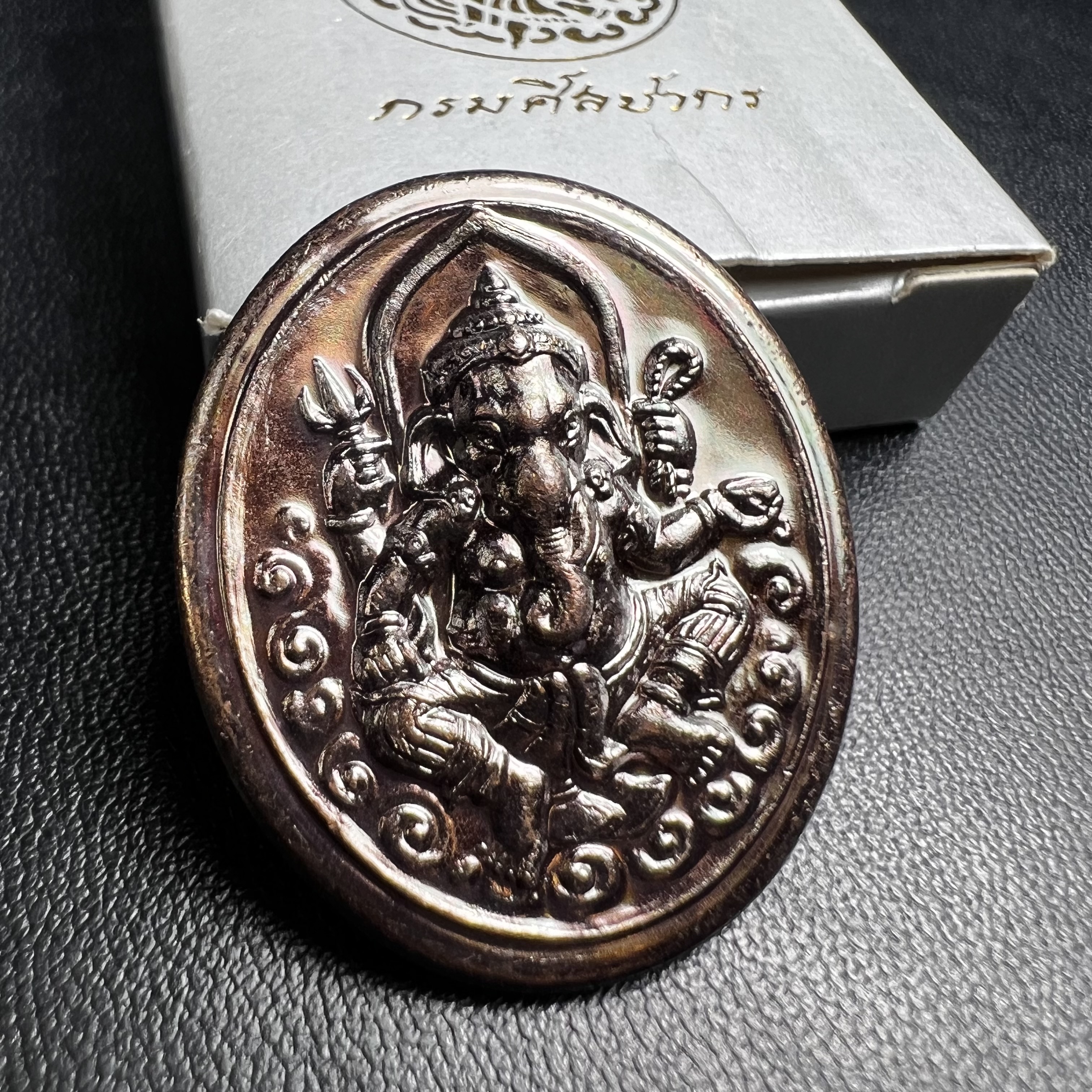 พระพิฆเนศ เทพเจ้าแห่งความสำเร็จและศิลปวิทยาการ กรมศิลปากร ปี 2547 เหรียญทองแดงรมดำ ขนาดสูง 3 ซ.ม. สภาพผิวสวยเดิม พร้อมกล่องบรรจุเดิมครบ