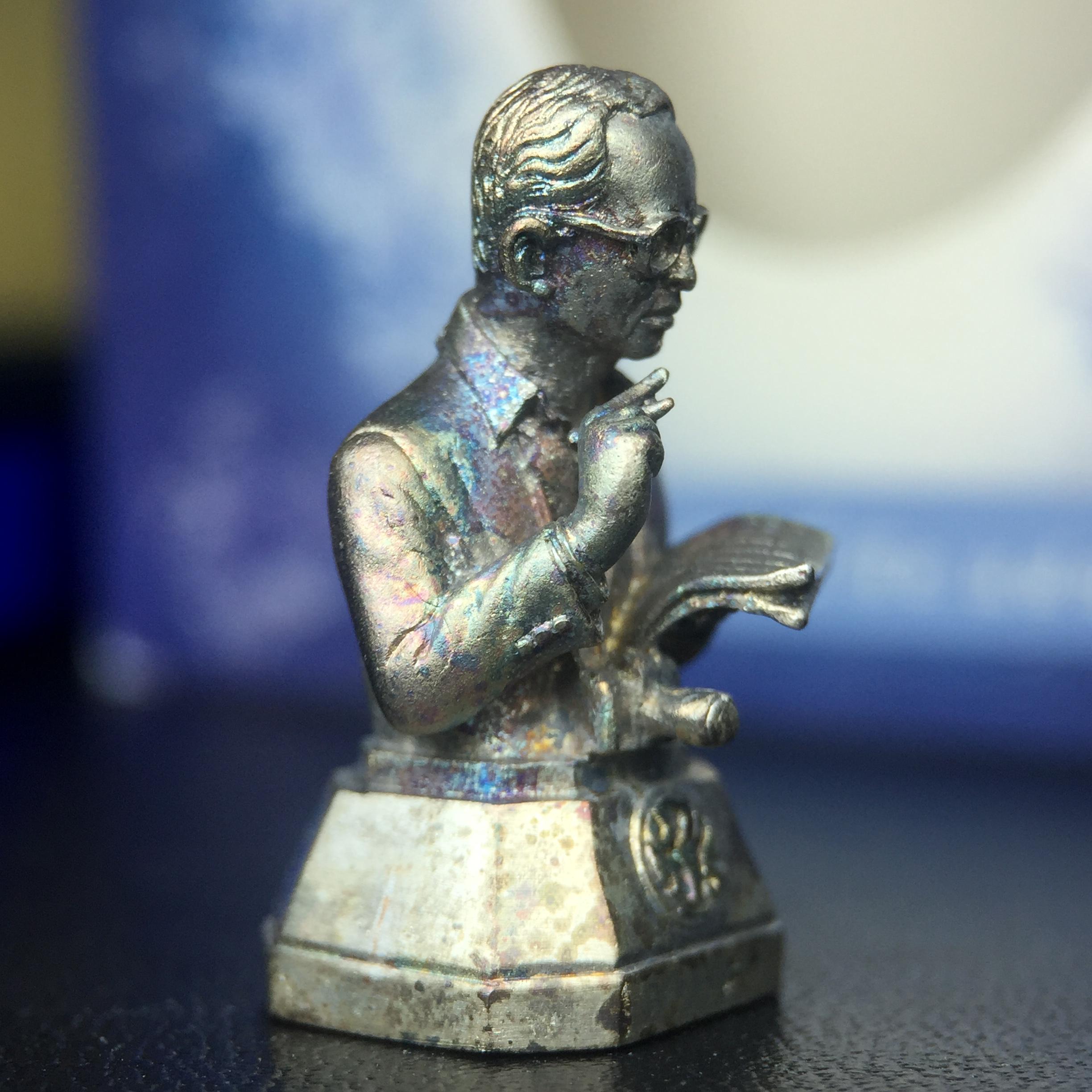 พระบรมรูปพระบาทสมเด็จพระเจ้าอยู่หัวรัชกาลที่ 9(ทรงงาน) ภปร. รุ่นเพราะแผ่นดินนี้คือแผ่นดินเกิด ปี 2551 ขนาดสูง 1 นิ้ว เนื้อเงิน(ผิวเดิมขึ้นสีรุ้งธรรมชาติสวยมาก)(ด้านหน้า ฐานพระบรมรูปฯ ประดิษฐานอักษรพระปรมาภิไธย ภ.ป.ร.)นิยมหายาก(1 ใน 5000 องค์)