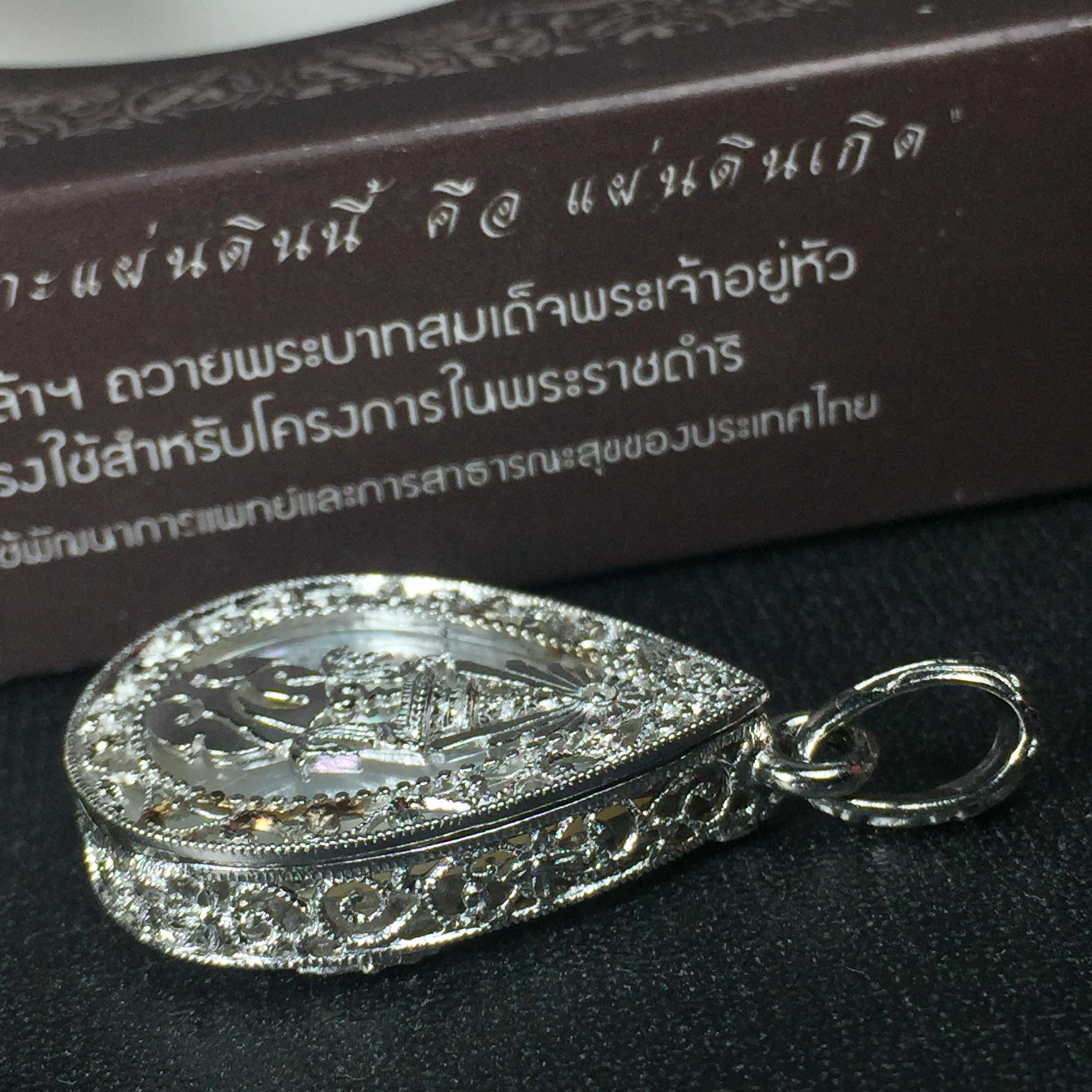 พระพุทธชินราช ภปร. โครงการ "เพราะแผ่นดินนี้ คือ แผ่นดินเกิด" ปี2548(รุ่นแรก) เหรียญทรงหยดน้ำ ขนาด 21 x 31 มม. เนื้อเงินสามกษัตริย์ องค์พระชุบสามกษัตริย์ ล้อมด้วยกรอบเงินชุบทองคำขาวสลักเสลาเป็นลวดลายละเอียดอ่อน ส่วนพื้นองค์พระเป็นเปลือกหอยมุข