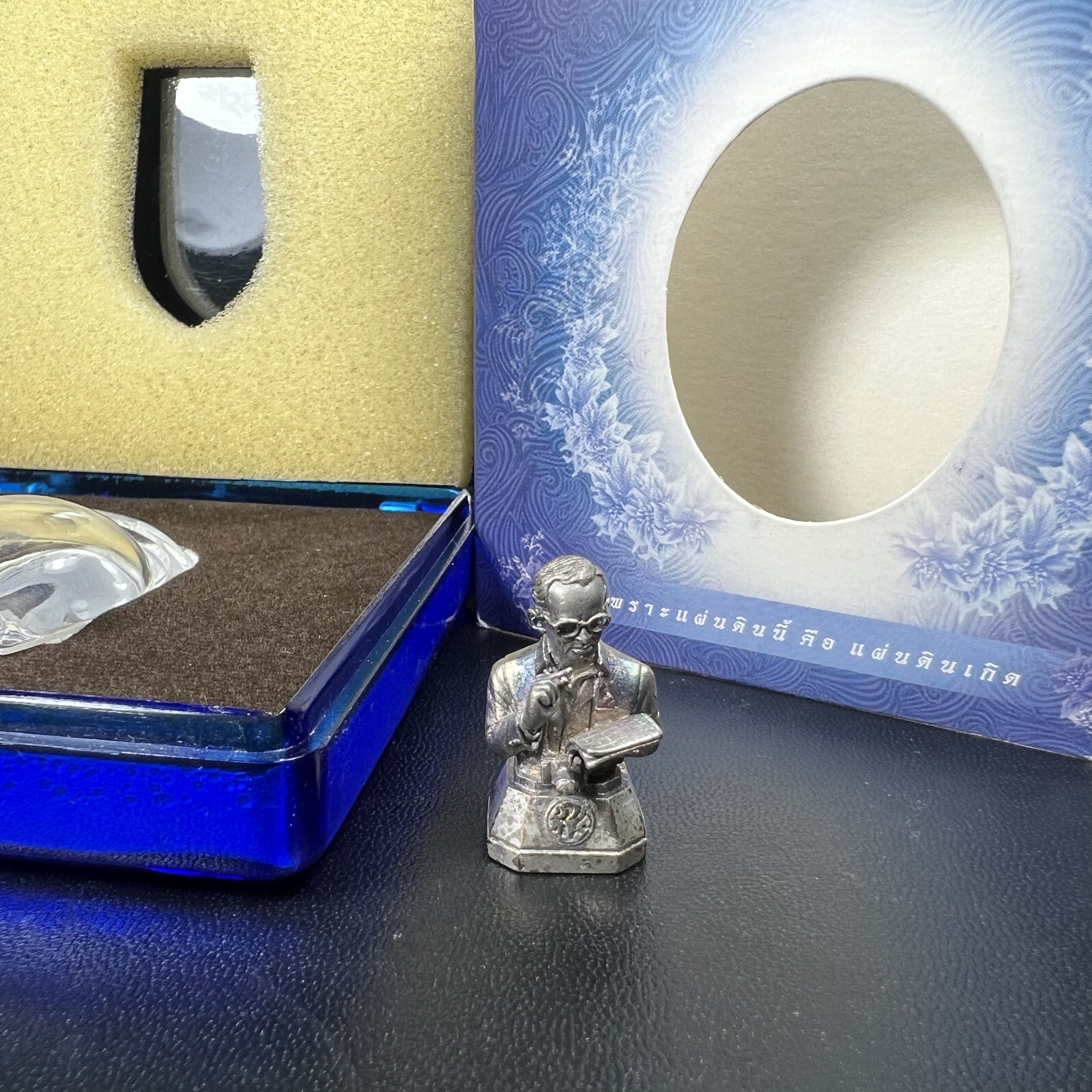 พระบรมรูปพระบาทสมเด็จพระเจ้าอยู่หัวรัชกาลที่ 9(ทรงงาน) ภปร. รุ่นเพราะแผ่นดินนี้คือแผ่นดินเกิด ปี 2551 ขนาดสูง 1 นิ้ว เนื้อเงิน(ผิวเดิมขึ้นสีรุ้งธรรมชาติสวยมาก)(ด้านหน้า ฐานพระบรมรูปฯ ประดิษฐานอักษรพระปรมาภิไธย ภ.ป.ร.)นิยมหายาก(1 ใน 5000 องค์)