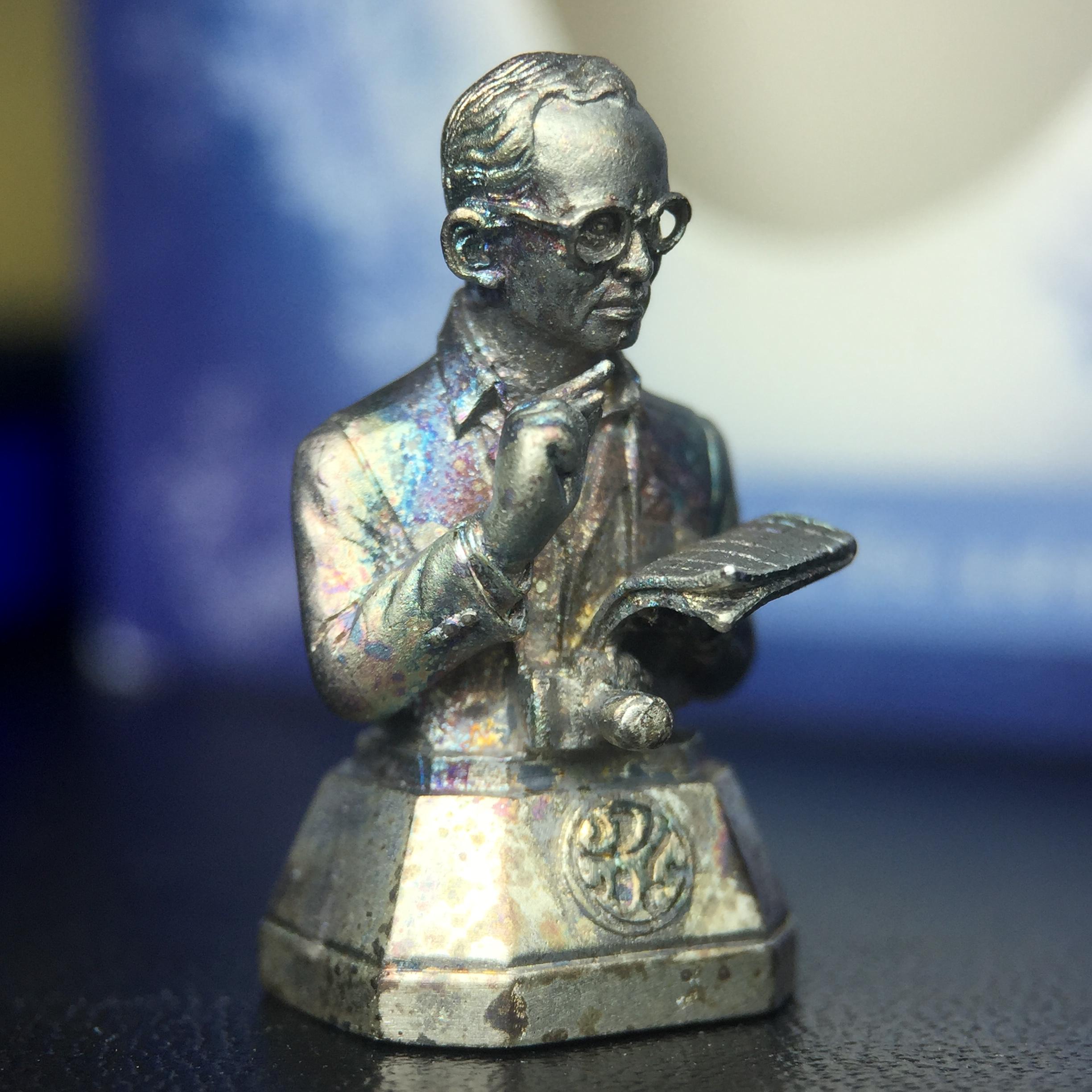 พระบรมรูปพระบาทสมเด็จพระเจ้าอยู่หัวรัชกาลที่ 9(ทรงงาน) ภปร. รุ่นเพราะแผ่นดินนี้คือแผ่นดินเกิด ปี 2551 ขนาดสูง 1 นิ้ว เนื้อเงิน(ผิวเดิมขึ้นสีรุ้งธรรมชาติสวยมาก)(ด้านหน้า ฐานพระบรมรูปฯ ประดิษฐานอักษรพระปรมาภิไธย ภ.ป.ร.)นิยมหายาก(1 ใน 5000 องค์)