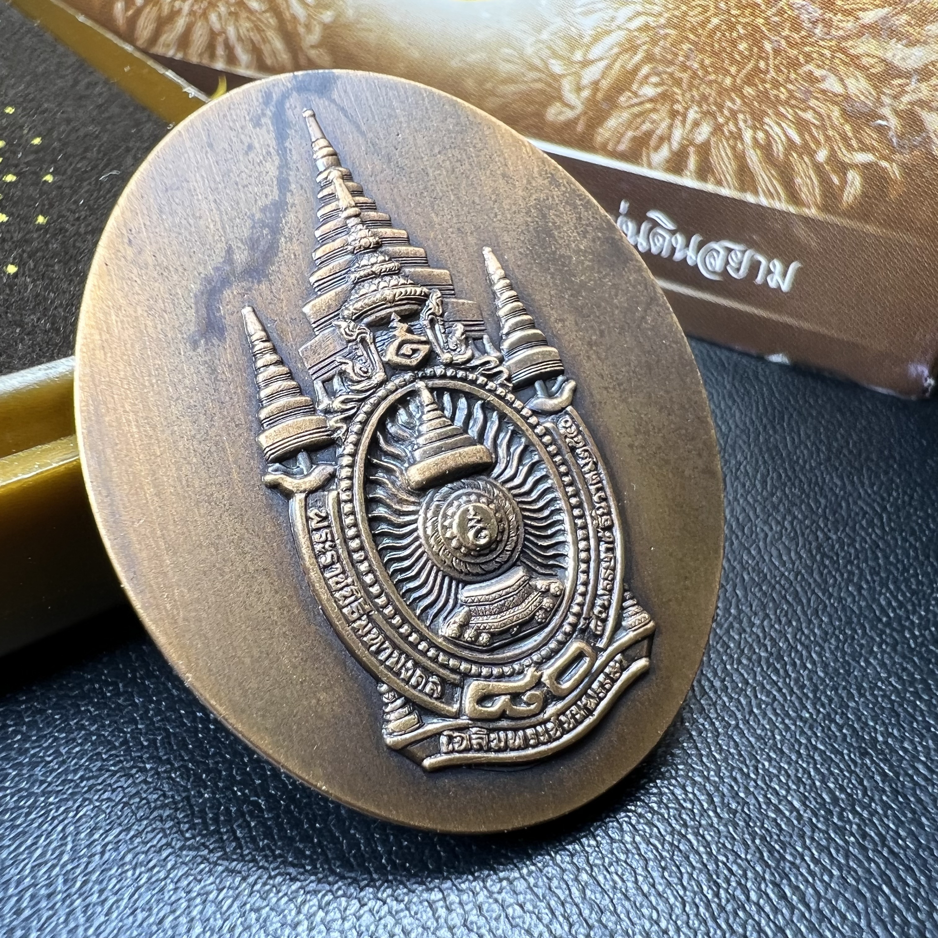 เหรียญรูปหล่อพระบาทสมเด็จพระเจ้าอยู่หัว ในหลวงทรงงาน “รุ่นเย็นศิระเพราะพระบริบาล 80พรรษา มหากษัตริย์คู่แผ่นดินสยาม” พ.ศ.2550 เนื้อทองแดงรมดำ(ขนาด 27*35 มม.)พร้อมกล่องบรรจุเดิมครบ