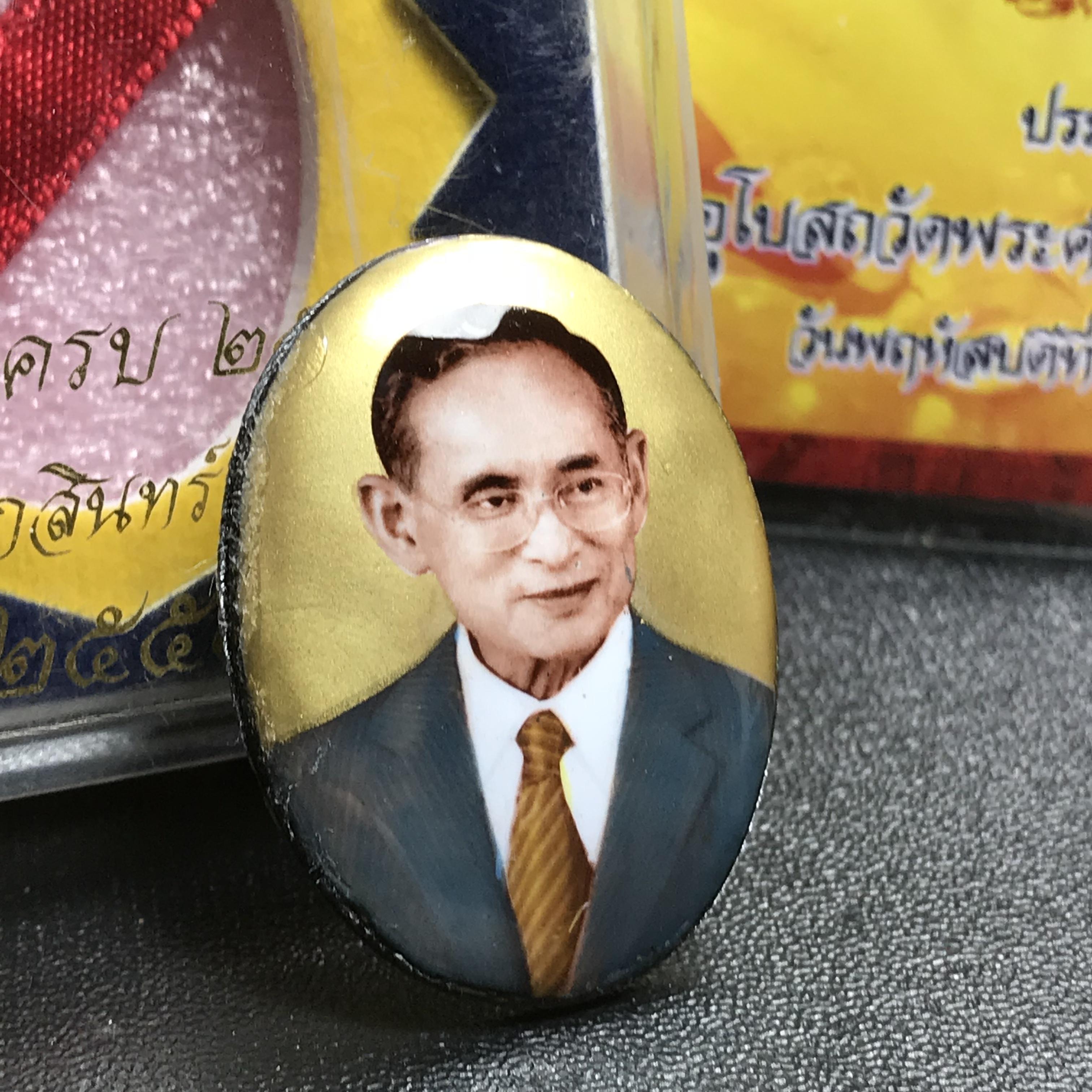 ล็อกเกตในหลวงรัชกาลที่9 ที่ระลึกครบ 25 ปี มูลนิธิศรีรัตนโกสินทร์ วัดสุทธาราม พ.ศ. 2550 พิมพ์ทรงวงรีรูปไข่ใหญ่ ฉากสีทอง หลังปิดแผ่นโลหะสีขาว(สแตนเลส)ฝังพระยอดธง(นิยม)