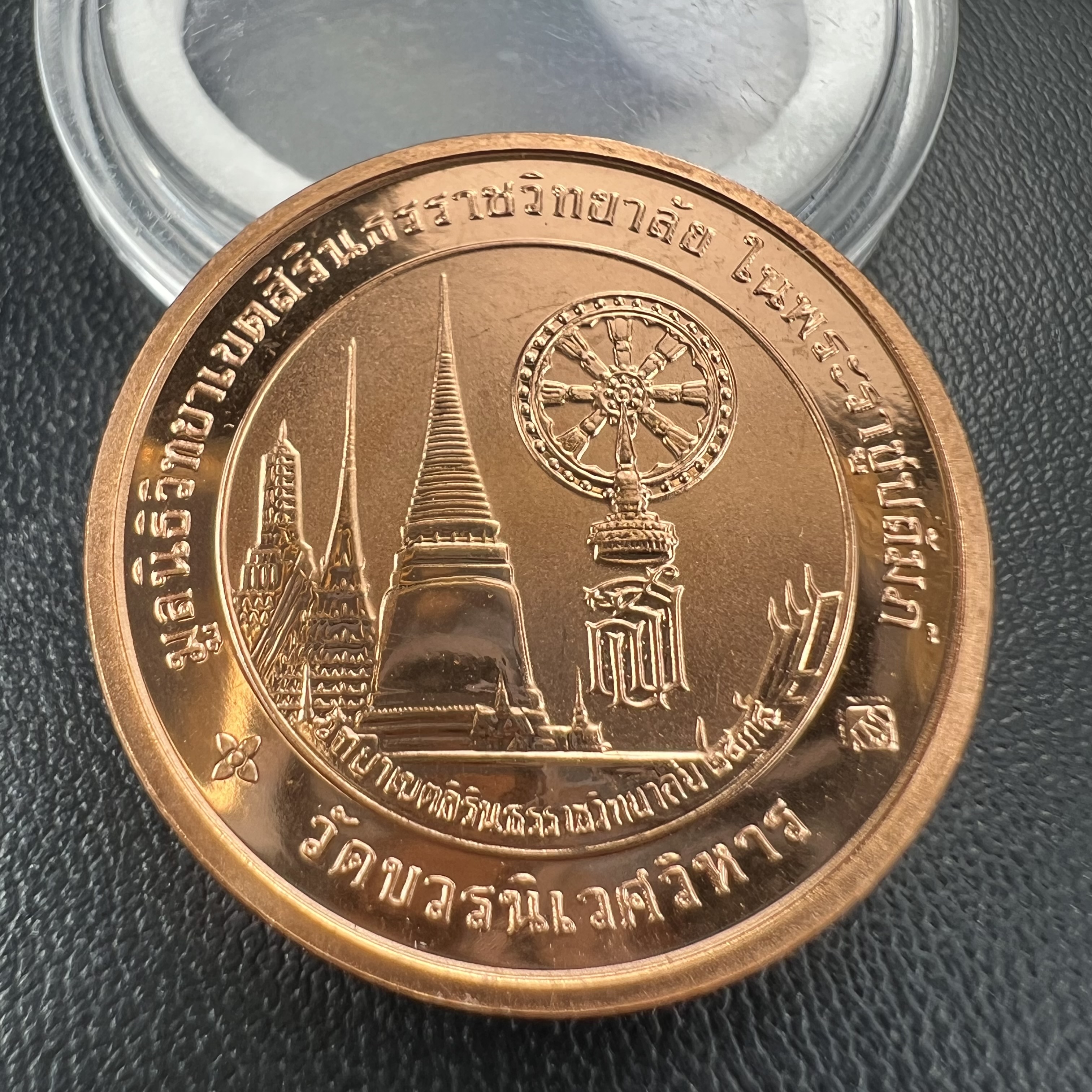 เหรียญพระแก้วมรกต ทรงเครื่องฤดูหนาว หลัง สธ.รุ่นเฉลิมพระเกียรติ ออกโดยมูลนิธิวิทยาเขตสิรินธรราชวิทยาลัย ในพระบรมราชูปถัมภ์ วัดบวรนิเวศวิหาร ปี 2538 เนื้อทองแดงบริสุทธิ์ 99.50% ขัดเงาสามมิติ ขนาด 2.7 ซม.ผลิตโดยโรงกษาปณ์ POB JOY MINT LTD.UK ประเทศอังกฤษ(เหร