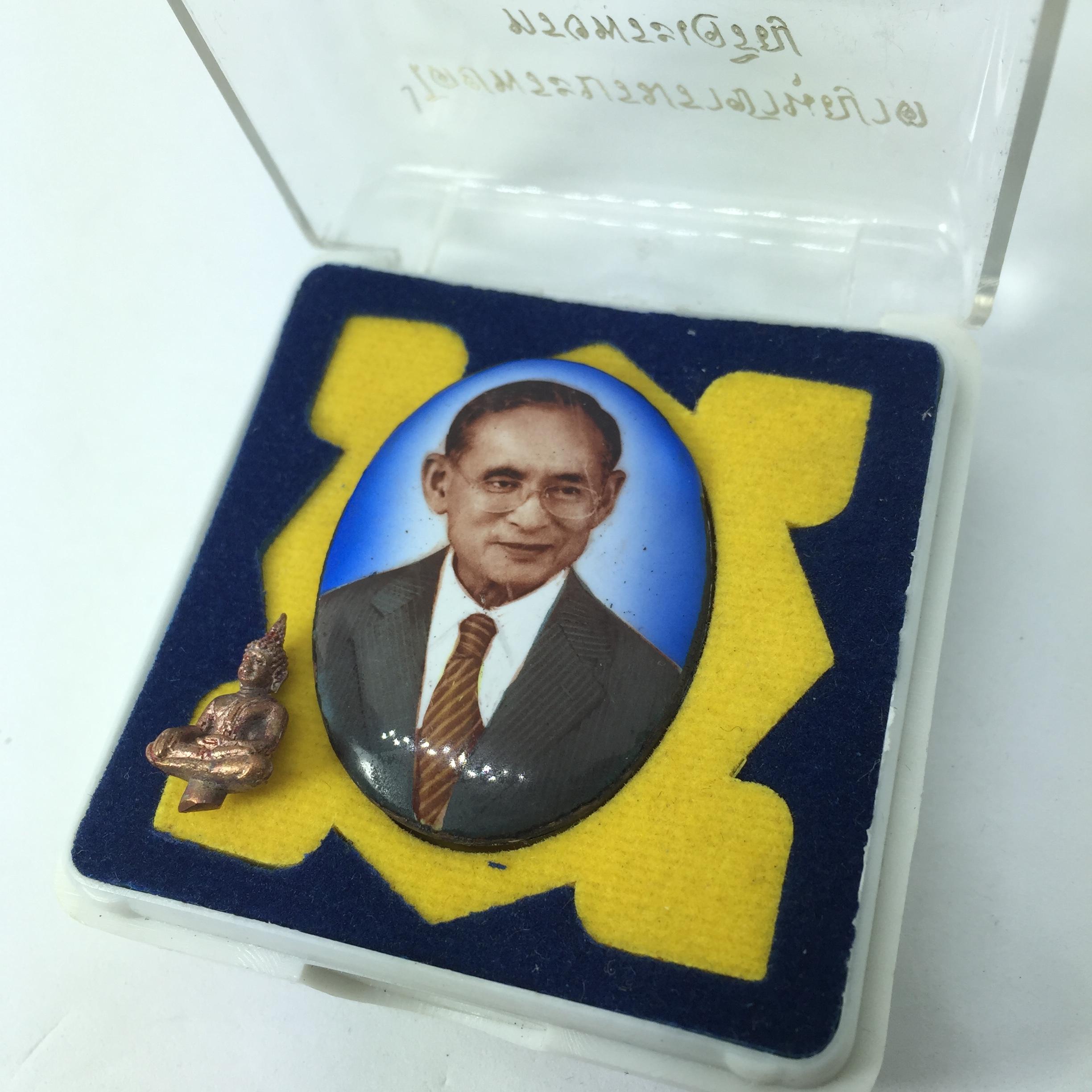 ล็อคเก็ต รัชกาลที่ ๙ พร้อมพระยอดธง พ.ศ. ๒๕๕๐ ที่ระลึกครบ ๒๕ ปี มูลนิธิศรีรัตนโกสินทร์ วัดสุทธาราม ฉากสีฟ้า หลังแผ่นโลหะแสตนเลส มหามงคลแห่งแผ่นดิน