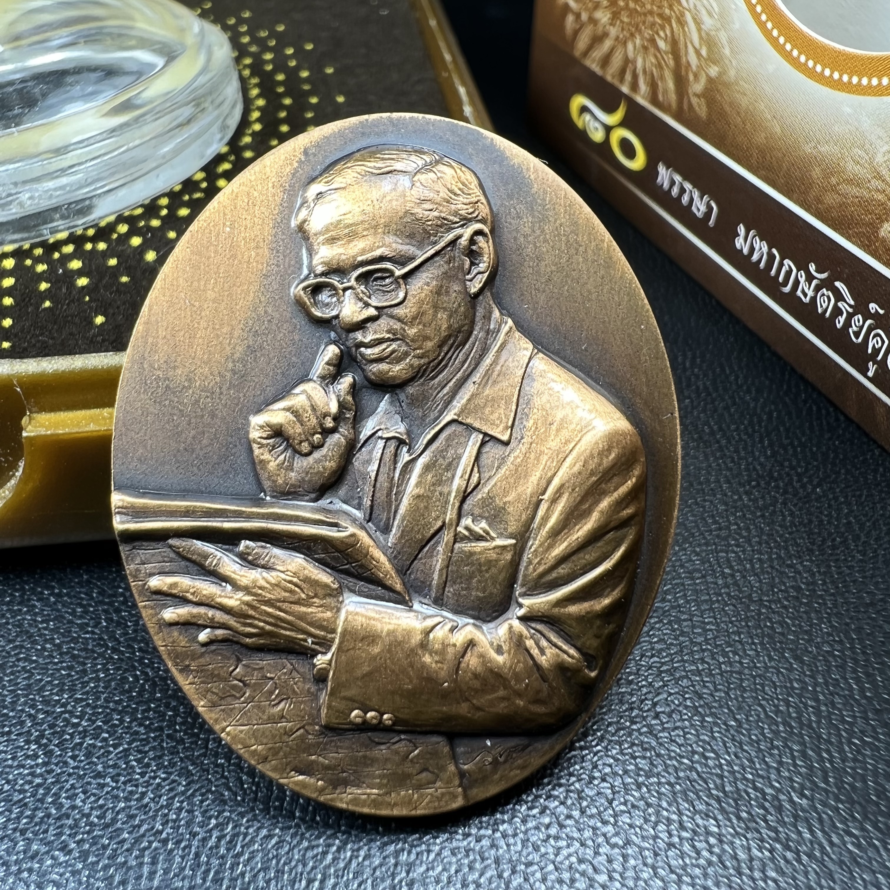 เหรียญรูปหล่อพระบาทสมเด็จพระเจ้าอยู่หัว ในหลวงทรงงาน “รุ่นเย็นศิระเพราะพระบริบาล 80พรรษา มหากษัตริย์คู่แผ่นดินสยาม” พ.ศ.2550 เนื้อทองแดงรมดำ(ขนาด 27*35 มม.)พร้อมกล่องบรรจุเดิมครบ