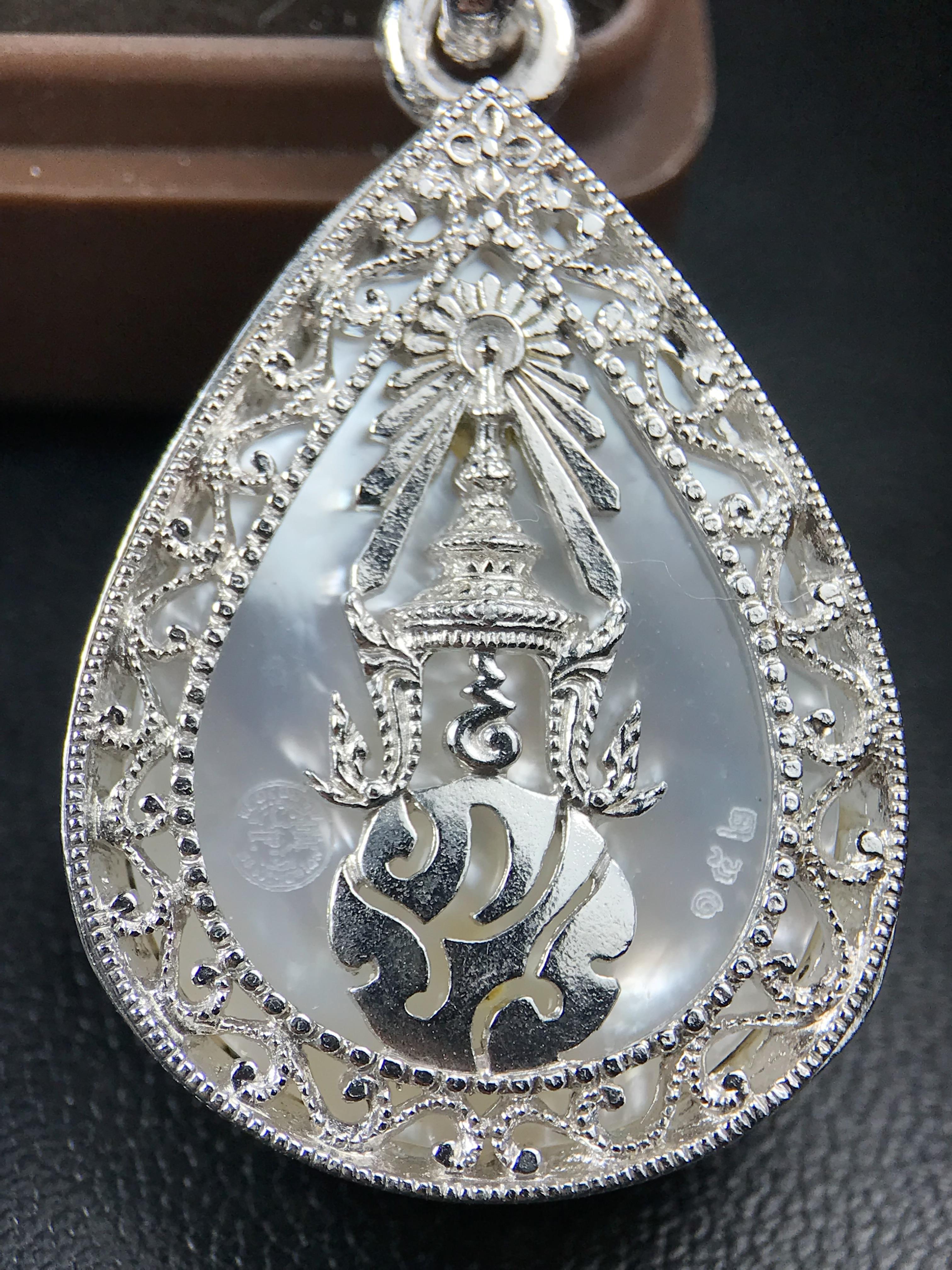 พระพุทธชินราช ภปร. โครงการ "เพราะแผ่นดินนี้ คือ แผ่นดินเกิด" ปี 2548(รุ่นแรก) เหรียญทรงหยดน้ำ ขนาด 21 x 31 มม. เนื้อเงินสามกษัตริย์ องค์พระชุบสามกษัตริย์ ล้อมด้วยกรอบเงินชุบทองคำขาวสลักเสลาเป็นลวดลายละเอียดอ่อน ส่วนพื้นองค์พระเป็นเปลือกหอยมุข