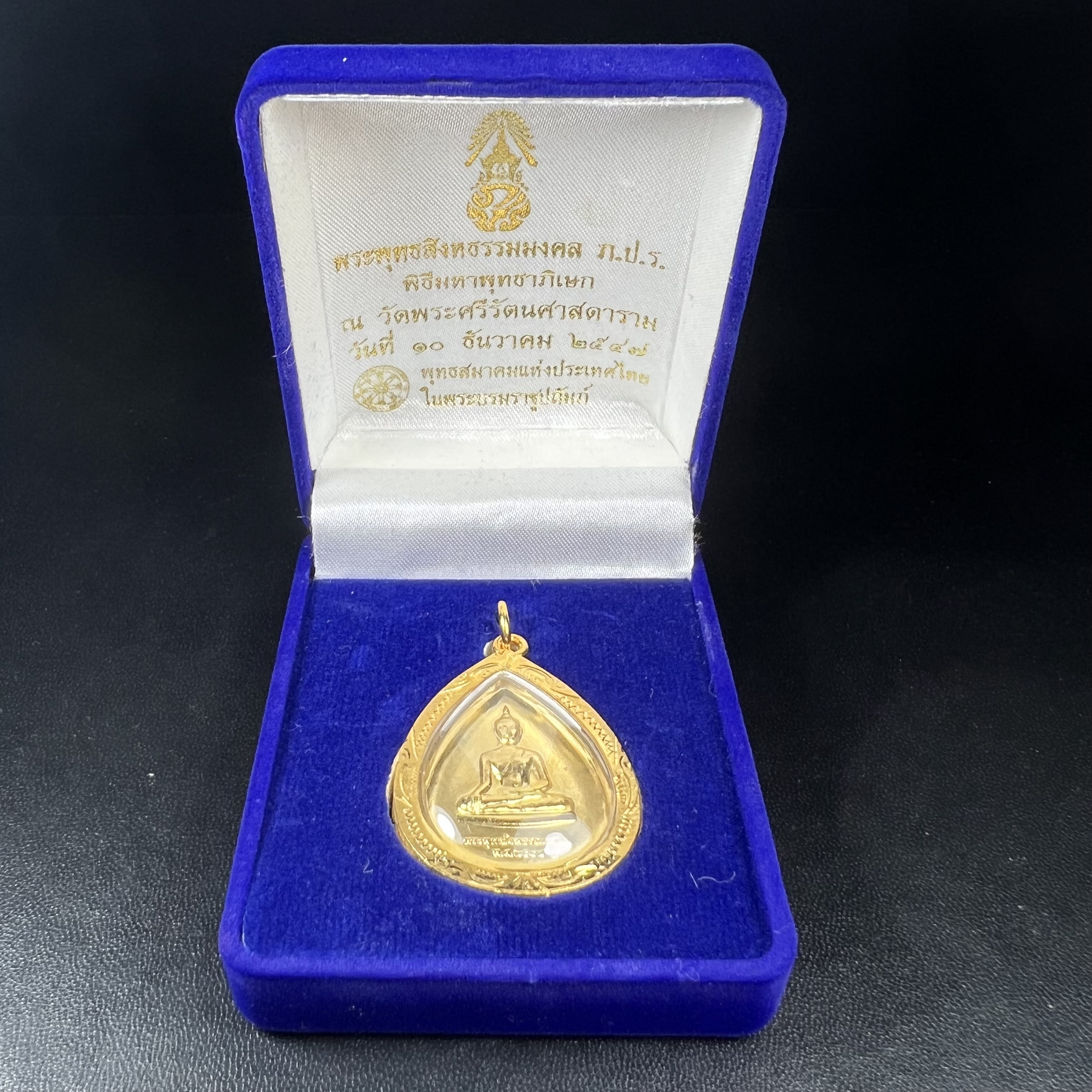 เหรียญพระพุทธสิงหธรรมมงคล ภปร. ปี 2547 ทรงหยดน้ำ ด้านหลังมี ภ.ป.ร. (ชนวนเก่า)เนื้อโลหะผสม ชุบทองเงา สูง 3.3ซม.พิธีใหญ่ มวลสารดี ปลุกเสกวัดพระแก้ว(งานเลี่ยมกรอบเดิมจากผู้จัดสร้างห่อหุ้มด้วยทองนพเกล้า)