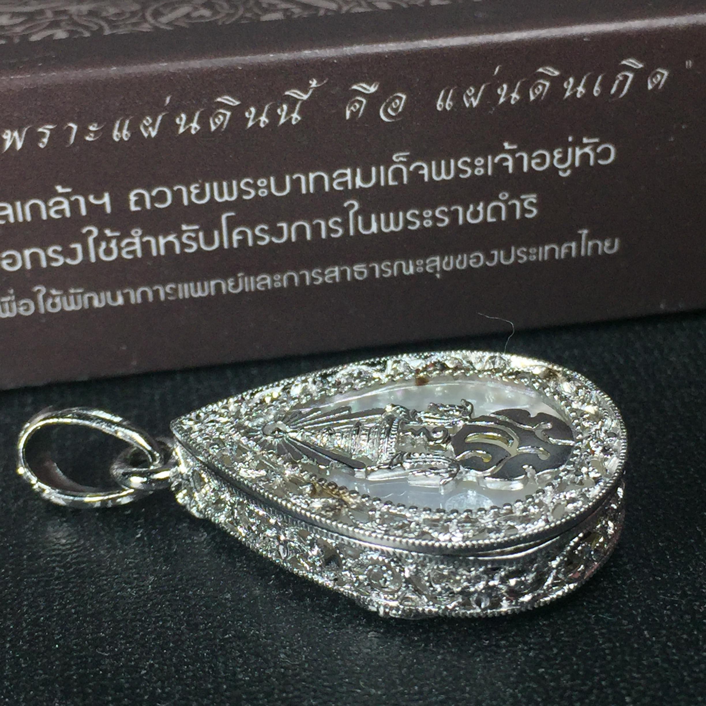 พระพุทธชินราช ภปร. โครงการ "เพราะแผ่นดินนี้ คือ แผ่นดินเกิด" ปี2548(รุ่นแรก) เหรียญทรงหยดน้ำ ขนาด 21 x 31 มม. เนื้อเงินสามกษัตริย์ องค์พระชุบสามกษัตริย์ ล้อมด้วยกรอบเงินชุบทองคำขาวสลักเสลาเป็นลวดลายละเอียดอ่อน ส่วนพื้นองค์พระเป็นเปลือกหอยมุข