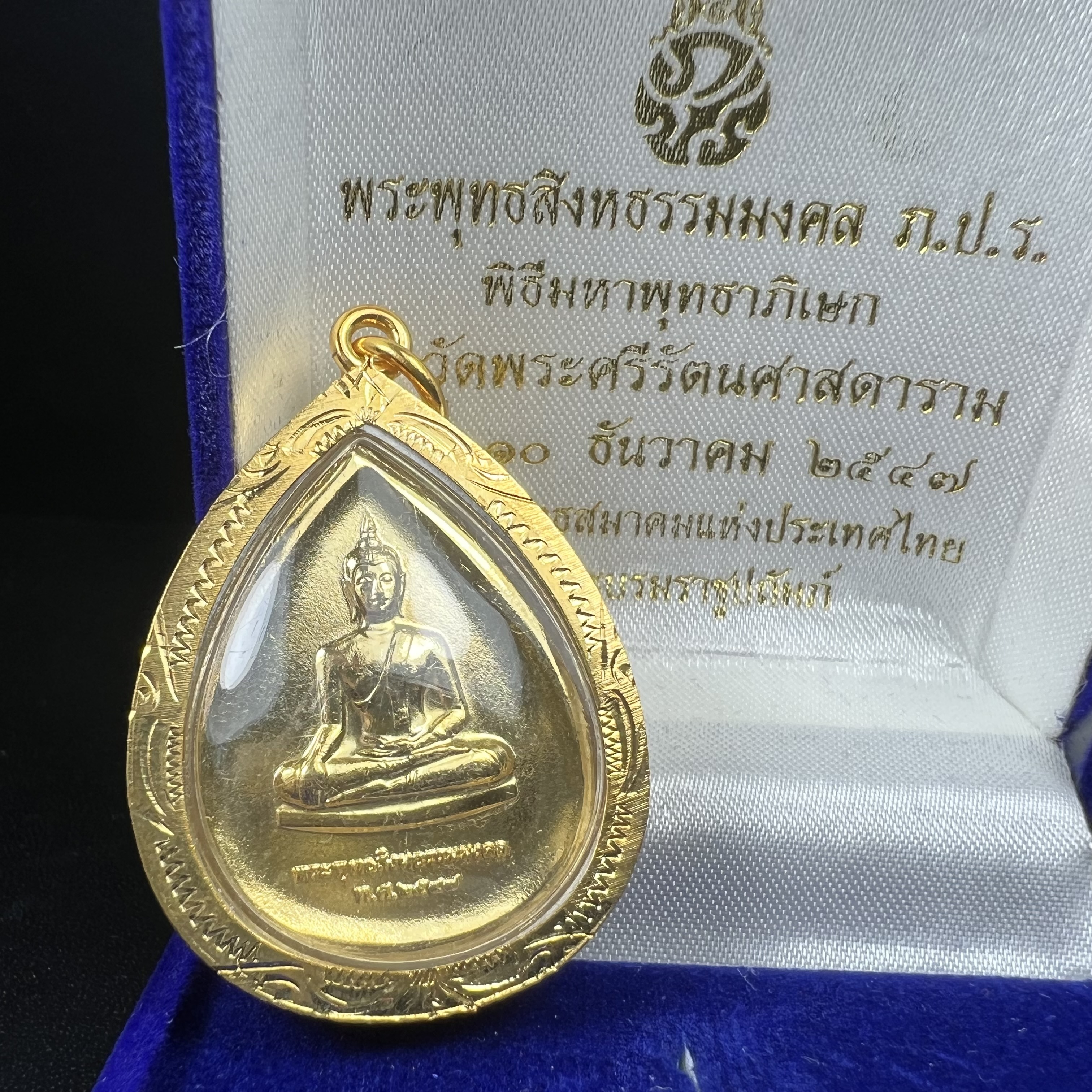 เหรียญพระพุทธสิงหธรรมมงคล ภปร. ปี 2547 ทรงหยดน้ำ ด้านหลังมี ภ.ป.ร. (ชนวนเก่า)เนื้อโลหะผสม ชุบทองเงา สูง 3.3ซม.พิธีใหญ่ มวลสารดี ปลุกเสกวัดพระแก้ว(งานเลี่ยมกรอบเดิมจากผู้จัดสร้างห่อหุ้มด้วยทองนพเกล้า)