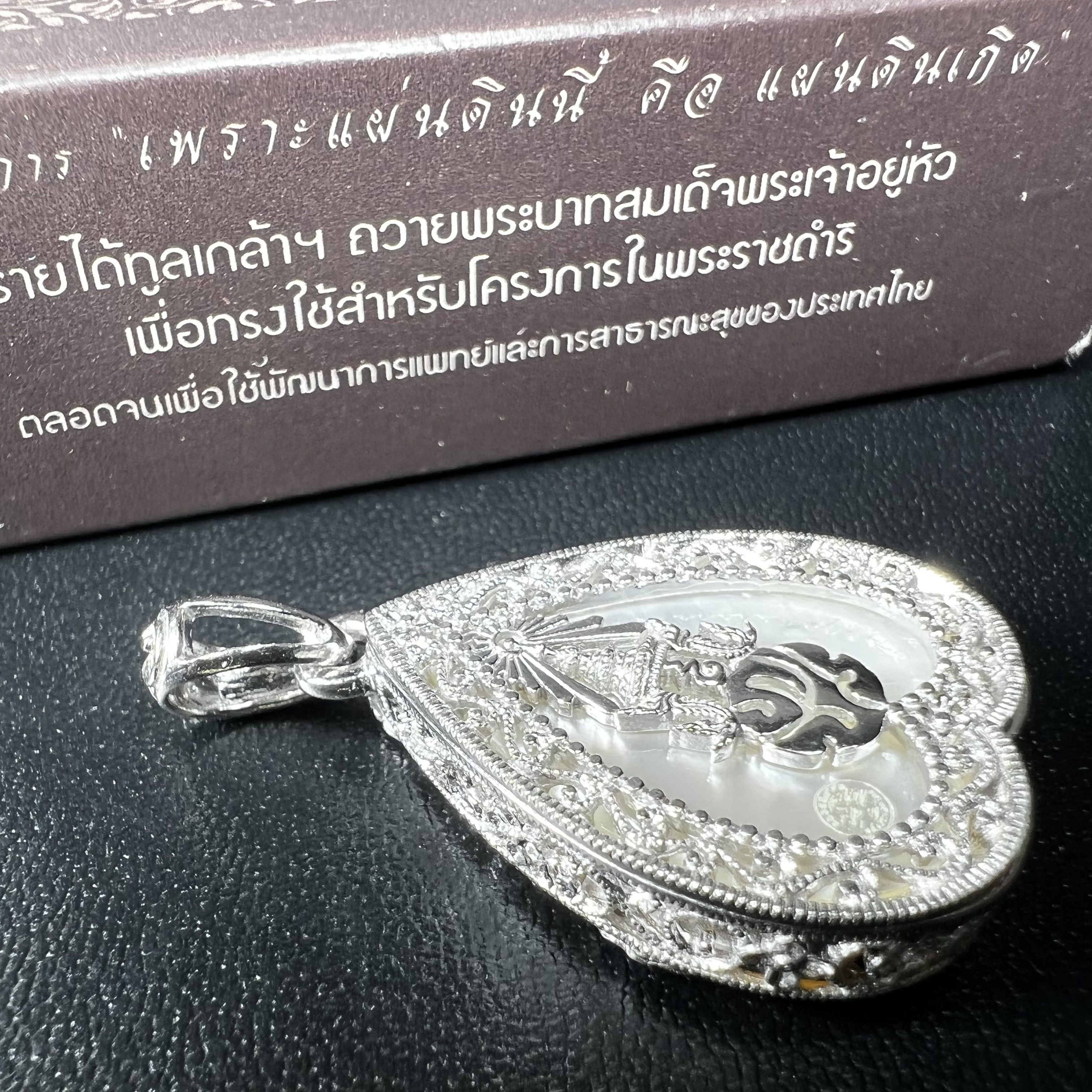 พระพุทธชินราช ภปร. โครงการ "เพราะแผ่นดินนี้ คือ แผ่นดินเกิด" ปี2548(รุ่นแรก) เหรียญทรงใบโพธิ์ ขนาด 21 x 29 มม. เนื้อเงินสามกษัตริย์ องค์พระชุบสามกษัตริย์ ล้อมด้วยกรอบเงินชุบทองคำขาวสลักเสลาเป็นลวดลายละเอียดอ่อน ส่วนพื้นองค์พระเป็นเปลือกหอยมุข