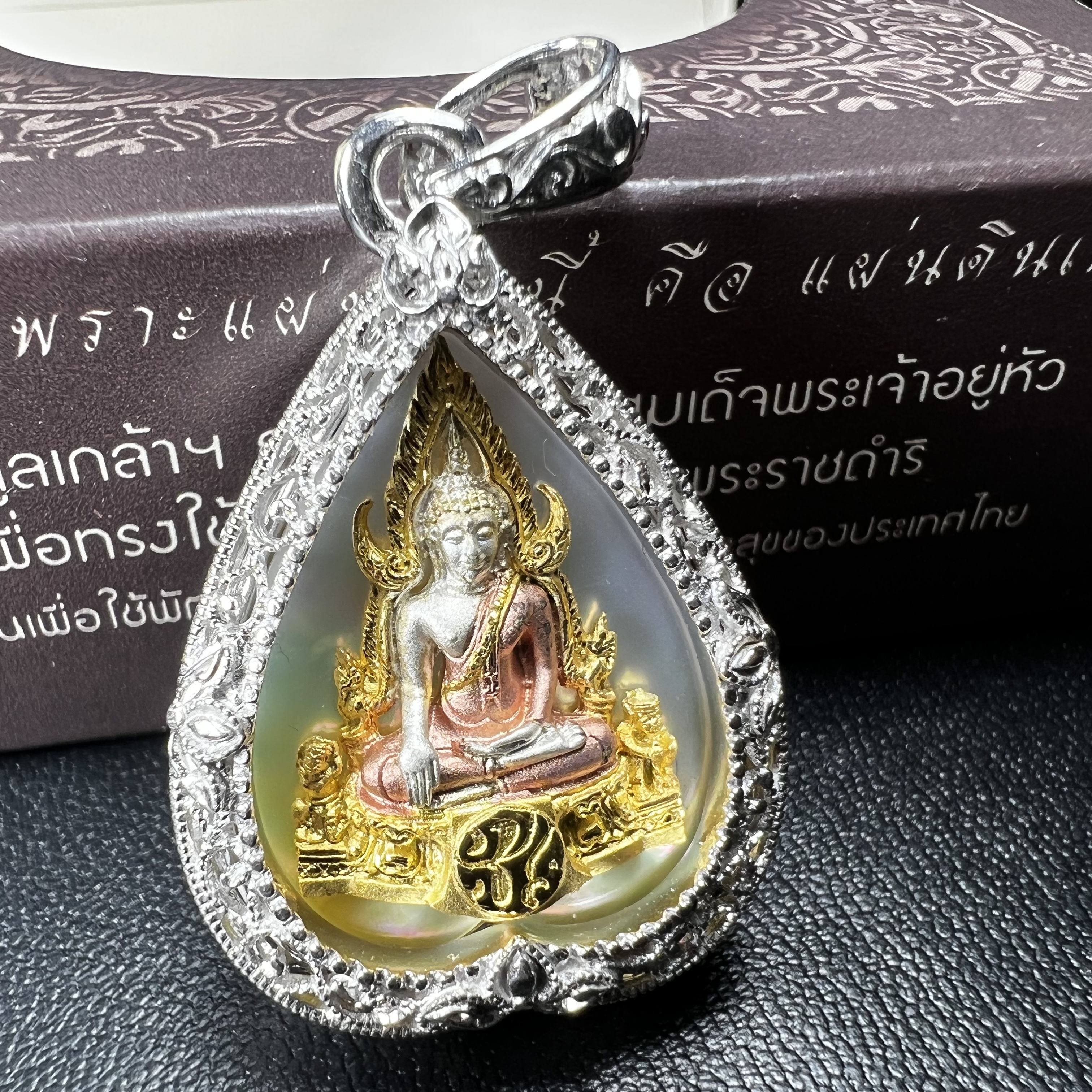 พระพุทธชินราช ภปร. โครงการ "เพราะแผ่นดินนี้ คือ แผ่นดินเกิด" ปี2548(รุ่นแรก) เหรียญทรงใบโพธิ์ ขนาด 21 x 29 มม. เนื้อเงินสามกษัตริย์ องค์พระชุบสามกษัตริย์ ล้อมด้วยกรอบเงินชุบทองคำขาวสลักเสลาเป็นลวดลายละเอียดอ่อน ส่วนพื้นองค์พระเป็นเปลือกหอยมุข