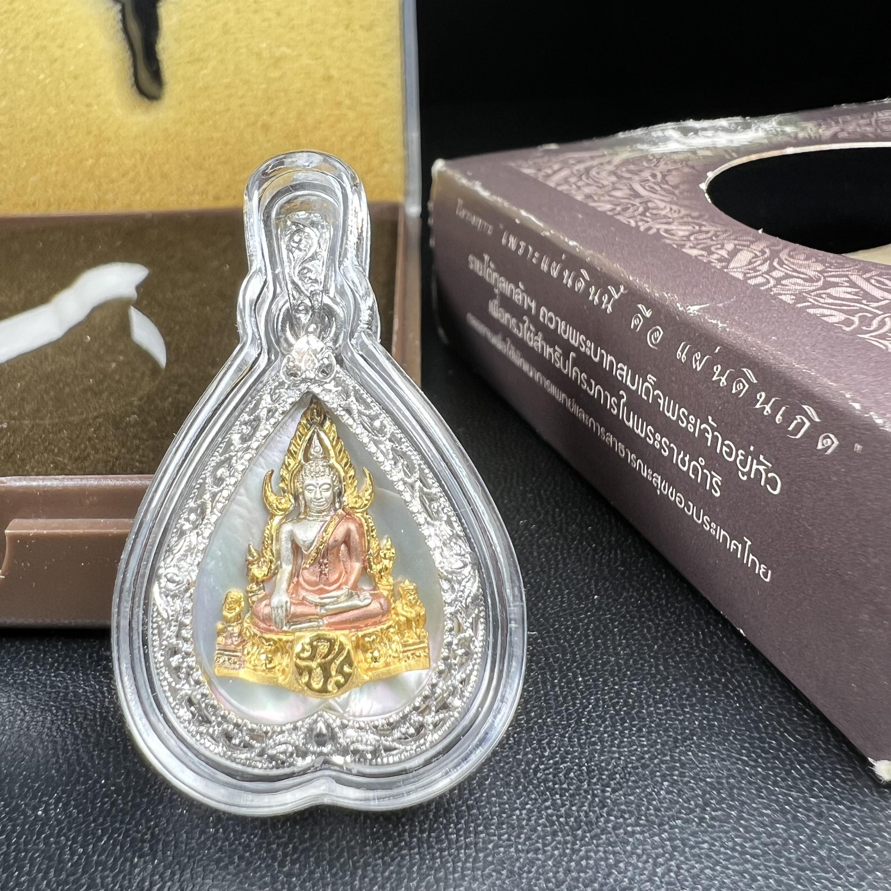 พระพุทธชินราช ภปร. โครงการ "เพราะแผ่นดินนี้ คือ แผ่นดินเกิด" ปี2548(รุ่นแรก) เหรียญทรงใบโพธิ์ ขนาด 21 x 29 มม. เนื้อเงินสามกษัตริย์ องค์พระชุบสามกษัตริย์ ล้อมด้วยกรอบเงินชุบทองคำขาวสลักเสลาเป็นลวดลายละเอียดอ่อน ส่วนพื้นองค์พระเป็นเปลือกหอยมุข