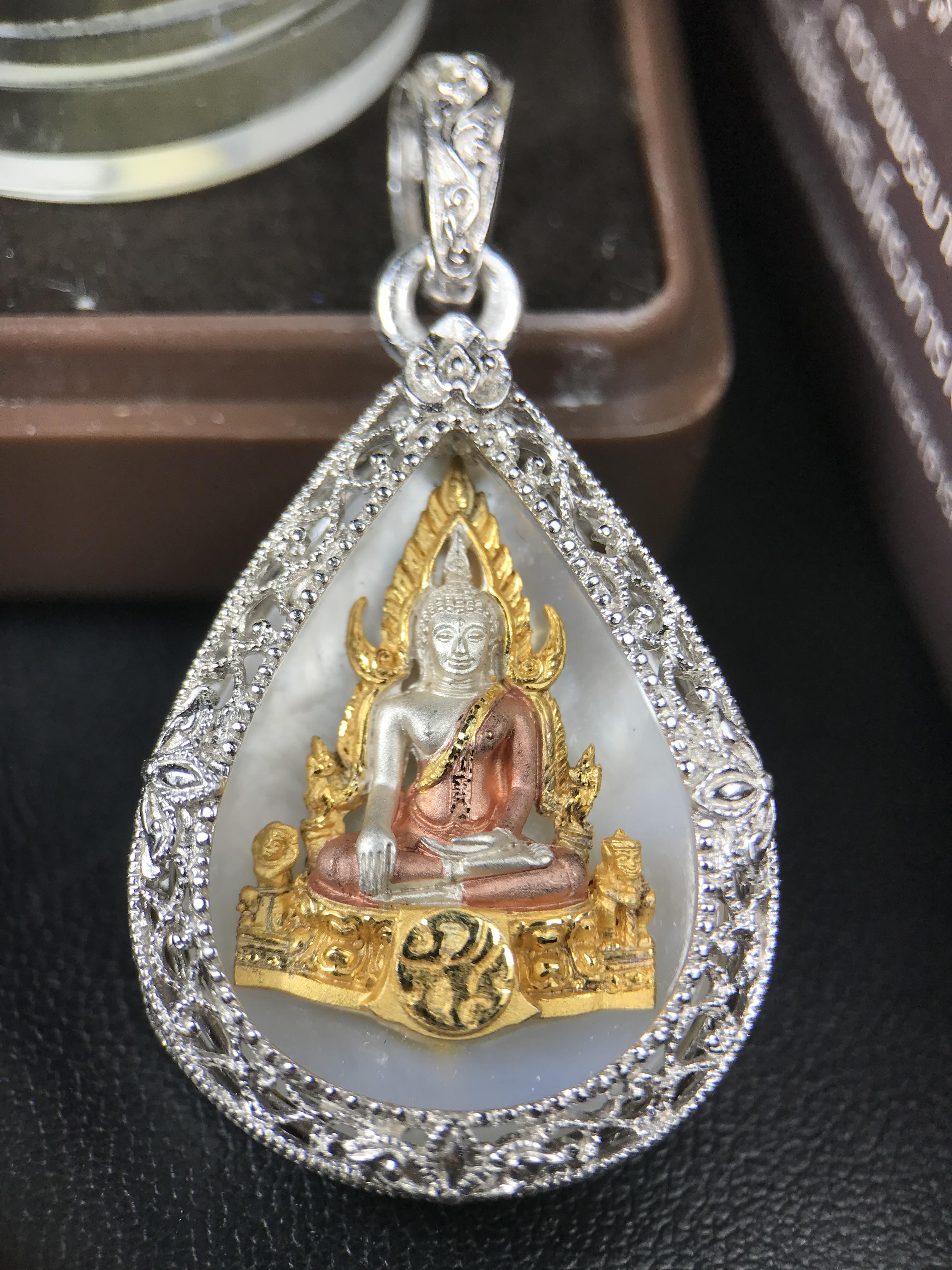 พระพุทธชินราช ภปร. โครงการ "เพราะแผ่นดินนี้ คือ แผ่นดินเกิด" ปี 2548(รุ่นแรก) เหรียญทรงหยดน้ำ ขนาด 21 x 31 มม. เนื้อเงินสามกษัตริย์ องค์พระชุบสามกษัตริย์ ล้อมด้วยกรอบเงินชุบทองคำขาวสลักเสลาเป็นลวดลายละเอียดอ่อน ส่วนพื้นองค์พระเป็นเปลือกหอยมุข