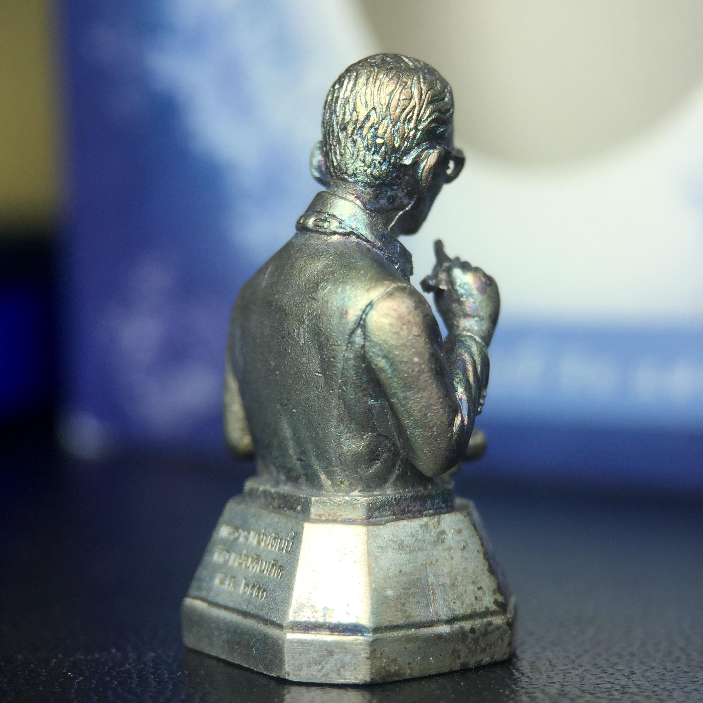 พระบรมรูปพระบาทสมเด็จพระเจ้าอยู่หัวรัชกาลที่ 9(ทรงงาน) ภปร. รุ่นเพราะแผ่นดินนี้คือแผ่นดินเกิด ปี 2551 ขนาดสูง 1 นิ้ว เนื้อเงิน(ผิวเดิมขึ้นสีรุ้งธรรมชาติสวยมาก)(ด้านหน้า ฐานพระบรมรูปฯ ประดิษฐานอักษรพระปรมาภิไธย ภ.ป.ร.)นิยมหายาก(1 ใน 5000 องค์)