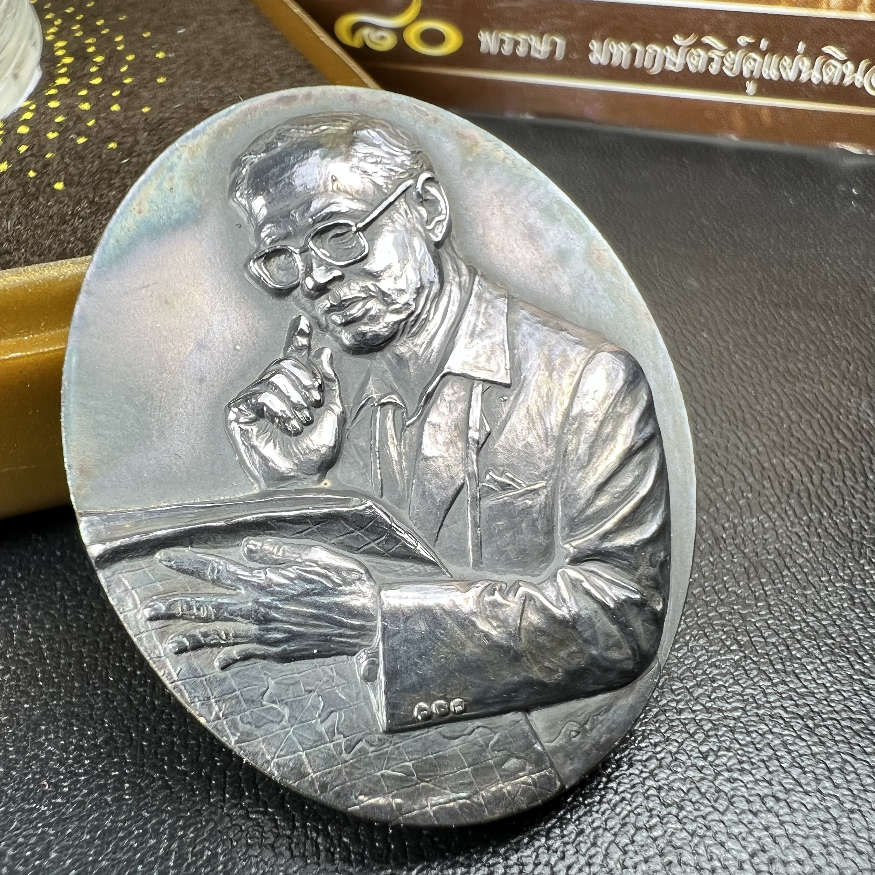 เหรียญรูปหล่อพระบาทสมเด็จพระเจ้าอยู่หัว ในหลวงทรงงาน “รุ่นเย็นศิระเพราะพระบริบาล 80พรรษา มหากษัตริย์คู่แผ่นดินสยาม” พ.ศ.2550 เนื้อเงินรมดำ(ขนาด 27*35 มม.) พร้อมกล่องบรรจุเดิมครบ