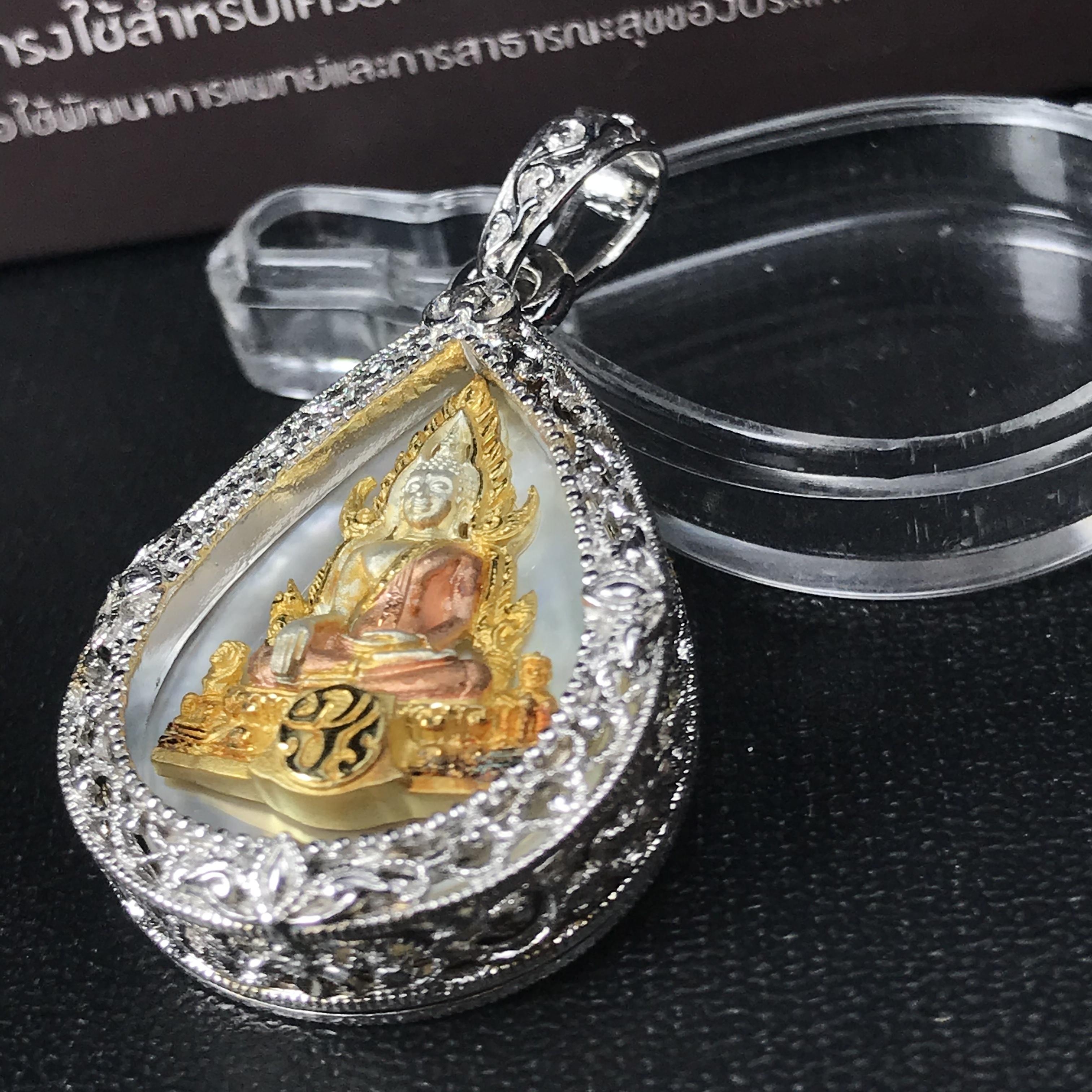 พระพุทธชินราช ภปร. โครงการ "เพราะแผ่นดินนี้ คือ แผ่นดินเกิด" ปี2548(รุ่นแรก) เหรียญทรงหยดน้ำ ขนาด 21 x 31 มม. เนื้อเงินสามกษัตริย์ องค์พระชุบสามกษัตริย์ ล้อมด้วยกรอบเงินชุบทองคำขาวสลักเสลาเป็นลวดลายละเอียดอ่อน ส่วนพื้นองค์พระเป็นเปลือกหอยมุข