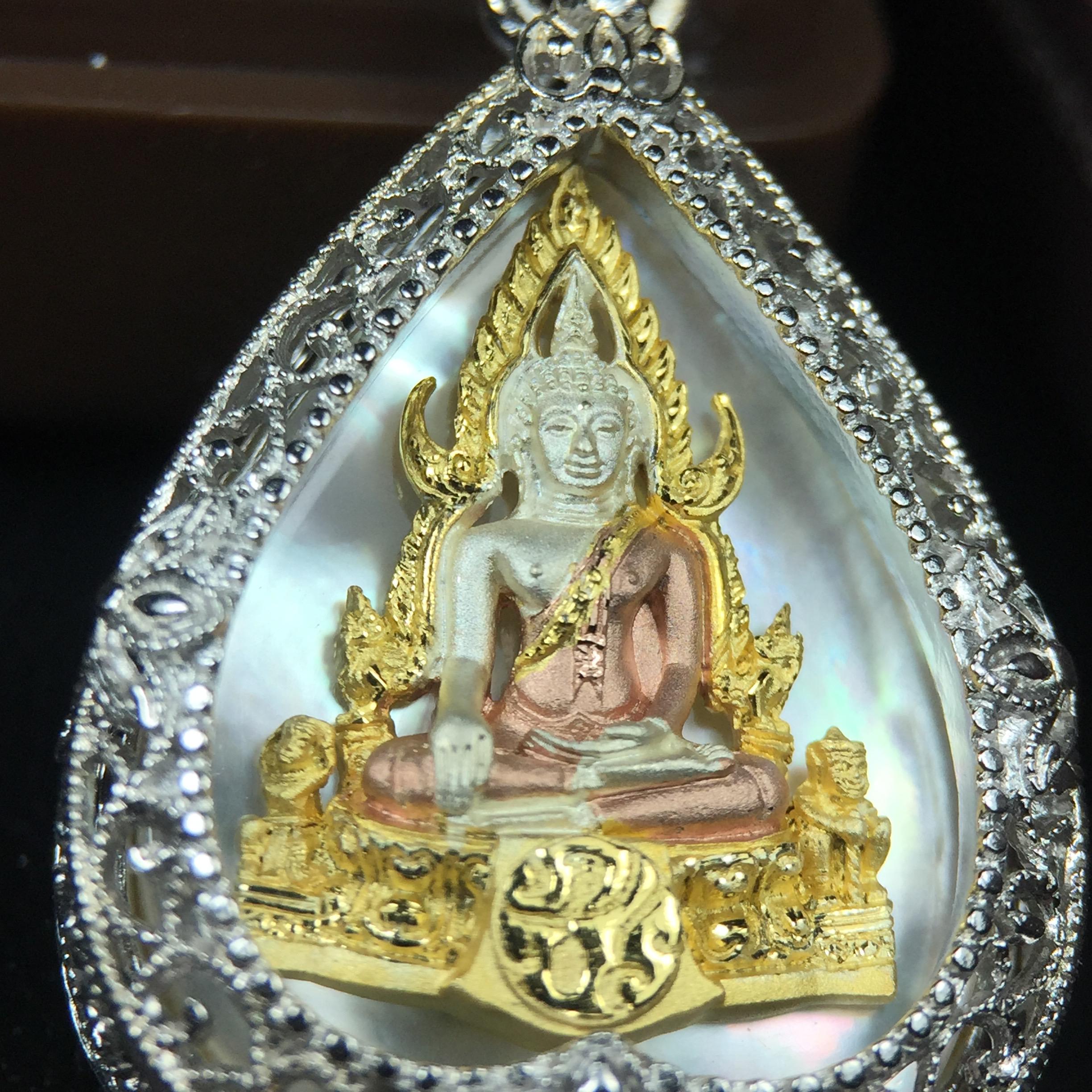 พระพุทธชินราช ภปร. โครงการ "เพราะแผ่นดินนี้ คือ แผ่นดินเกิด" ปี2548(รุ่นแรก) เหรียญทรงใบโพธิ์ ขนาด 21 x 29 มม. เนื้อเงินสามกษัตริย์ องค์พระชุบสามกษัตริย์ ล้อมด้วยกรอบเงินชุบทองคำขาวสลักเสลาเป็นลวดลายละเอียดอ่อน ส่วนพื้นองค์พระเป็นเปลือกหอยมุข