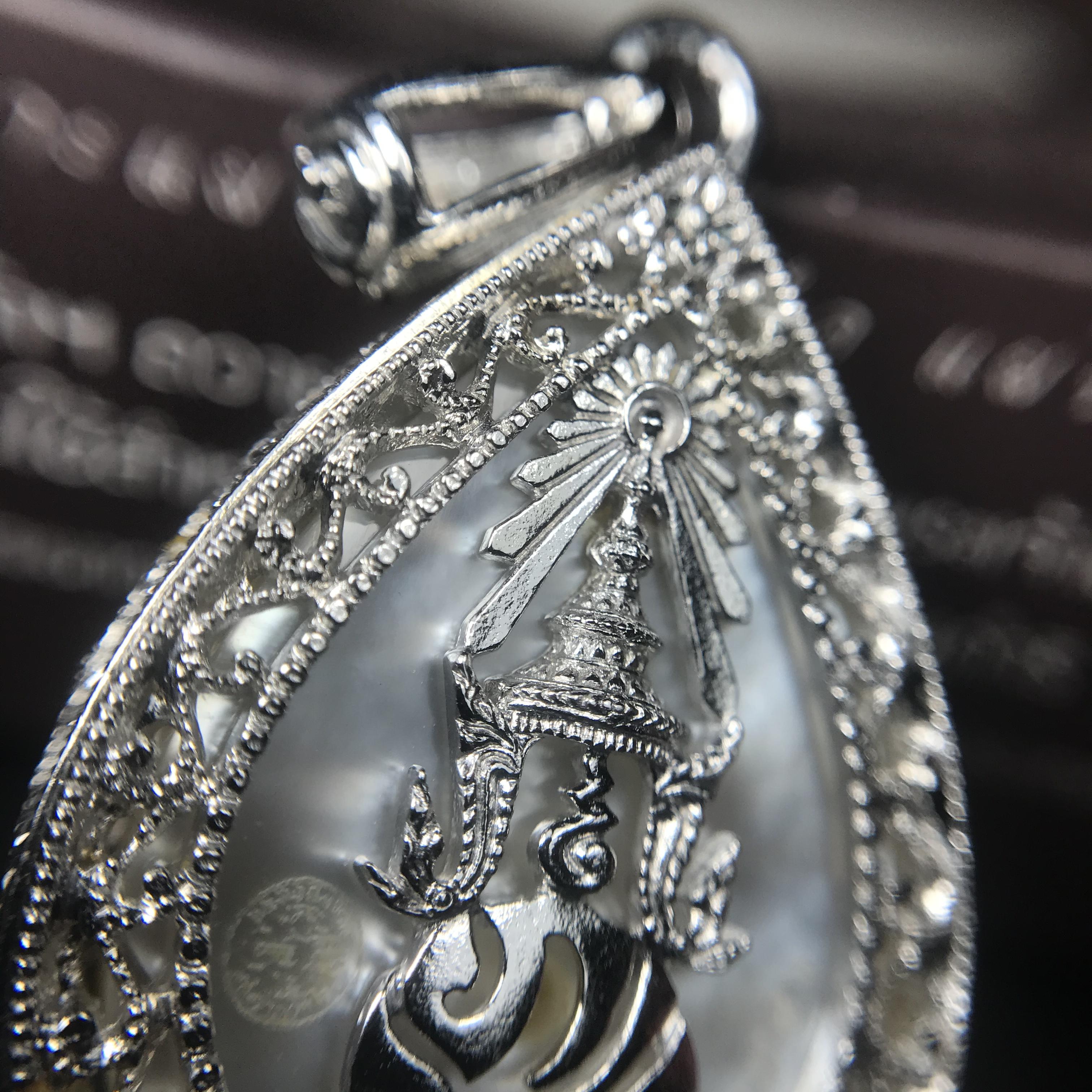 พระพุทธชินราช ภปร. โครงการ "เพราะแผ่นดินนี้ คือ แผ่นดินเกิด" ปี2548(รุ่นแรก) เหรียญทรงหยดน้ำ ขนาด 21 x 31 มม. เนื้อเงินสามกษัตริย์ องค์พระชุบสามกษัตริย์ ล้อมด้วยกรอบเงินชุบทองคำขาวสลักเสลาเป็นลวดลายละเอียดอ่อน ส่วนพื้นองค์พระเป็นเปลือกหอยมุข