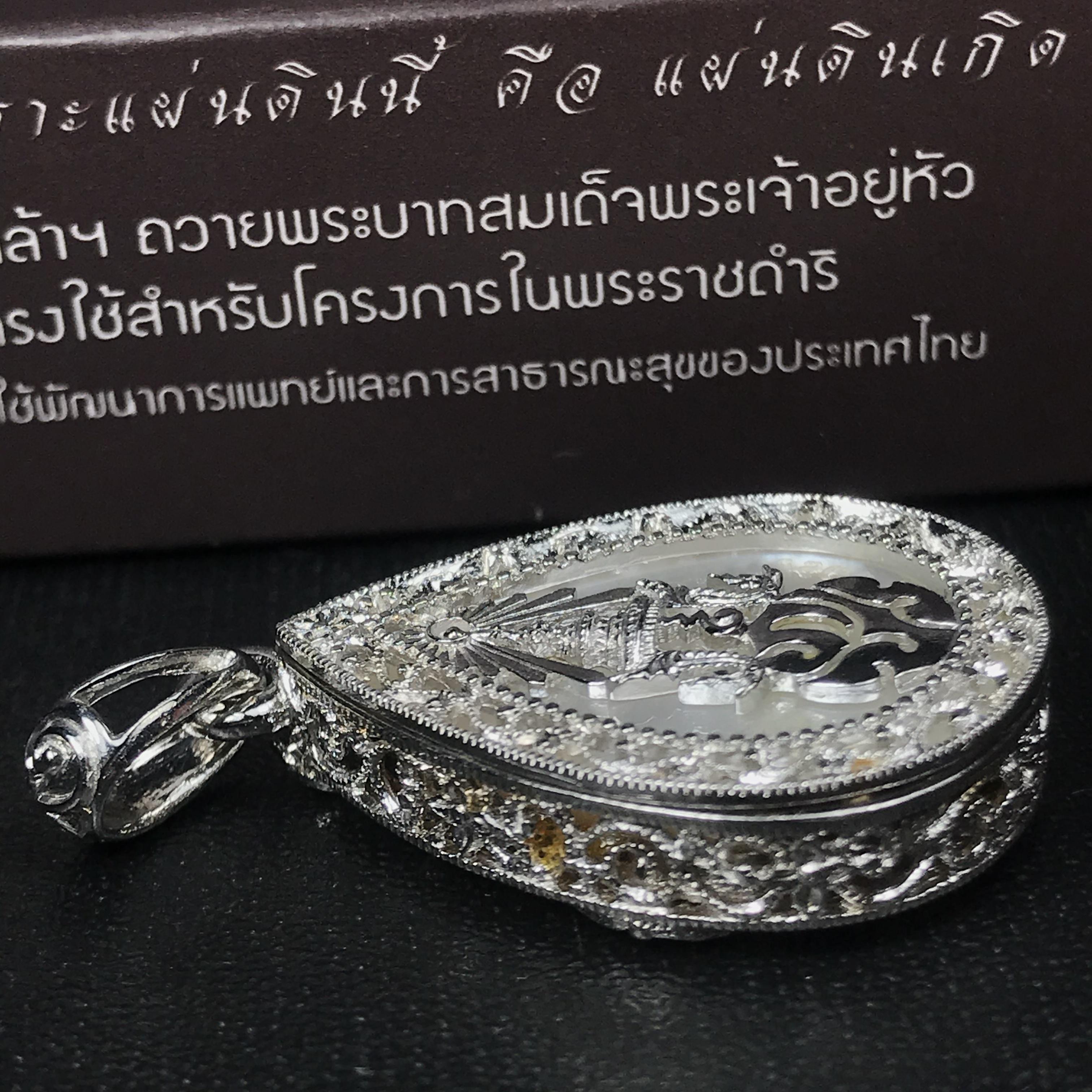 พระพุทธชินราช ภปร. โครงการ "เพราะแผ่นดินนี้ คือ แผ่นดินเกิด" ปี2548(รุ่นแรก) เหรียญทรงหยดน้ำ ขนาด 21 x 31 มม. เนื้อเงินสามกษัตริย์ องค์พระชุบสามกษัตริย์ ล้อมด้วยกรอบเงินชุบทองคำขาวสลักเสลาเป็นลวดลายละเอียดอ่อน ส่วนพื้นองค์พระเป็นเปลือกหอยมุข