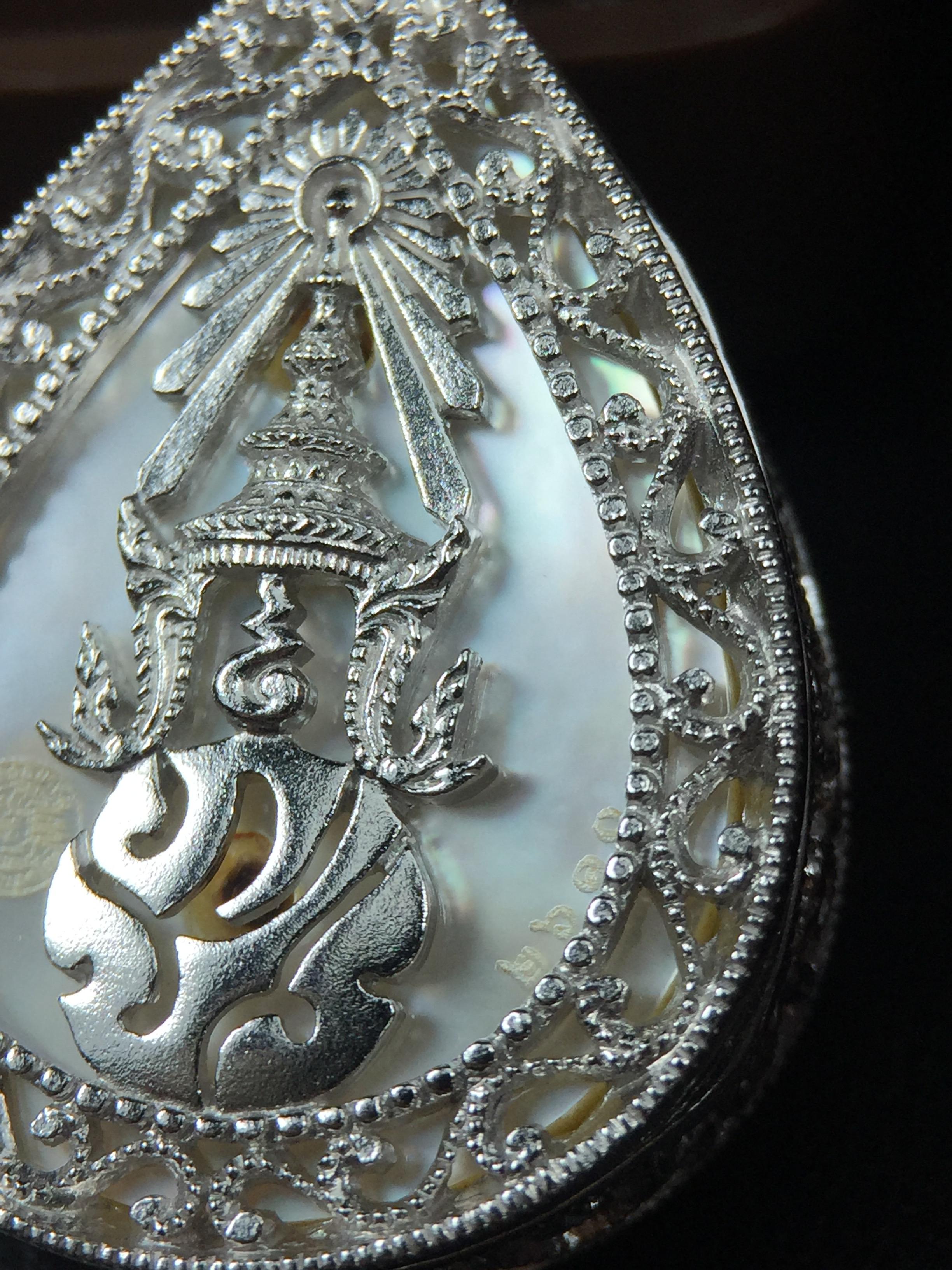 พระพุทธชินราช ภปร. โครงการ "เพราะแผ่นดินนี้ คือ แผ่นดินเกิด" ปี2548(รุ่นแรก) เหรียญทรงหยดน้ำ ขนาด 21 x 31 มม. เนื้อเงินสามกษัตริย์ องค์พระชุบสามกษัตริย์ ล้อมด้วยกรอบเงินชุบทองคำขาวสลักเสลาเป็นลวดลายละเอียดอ่อน ส่วนพื้นองค์พระเป็นเปลือกหอยมุข