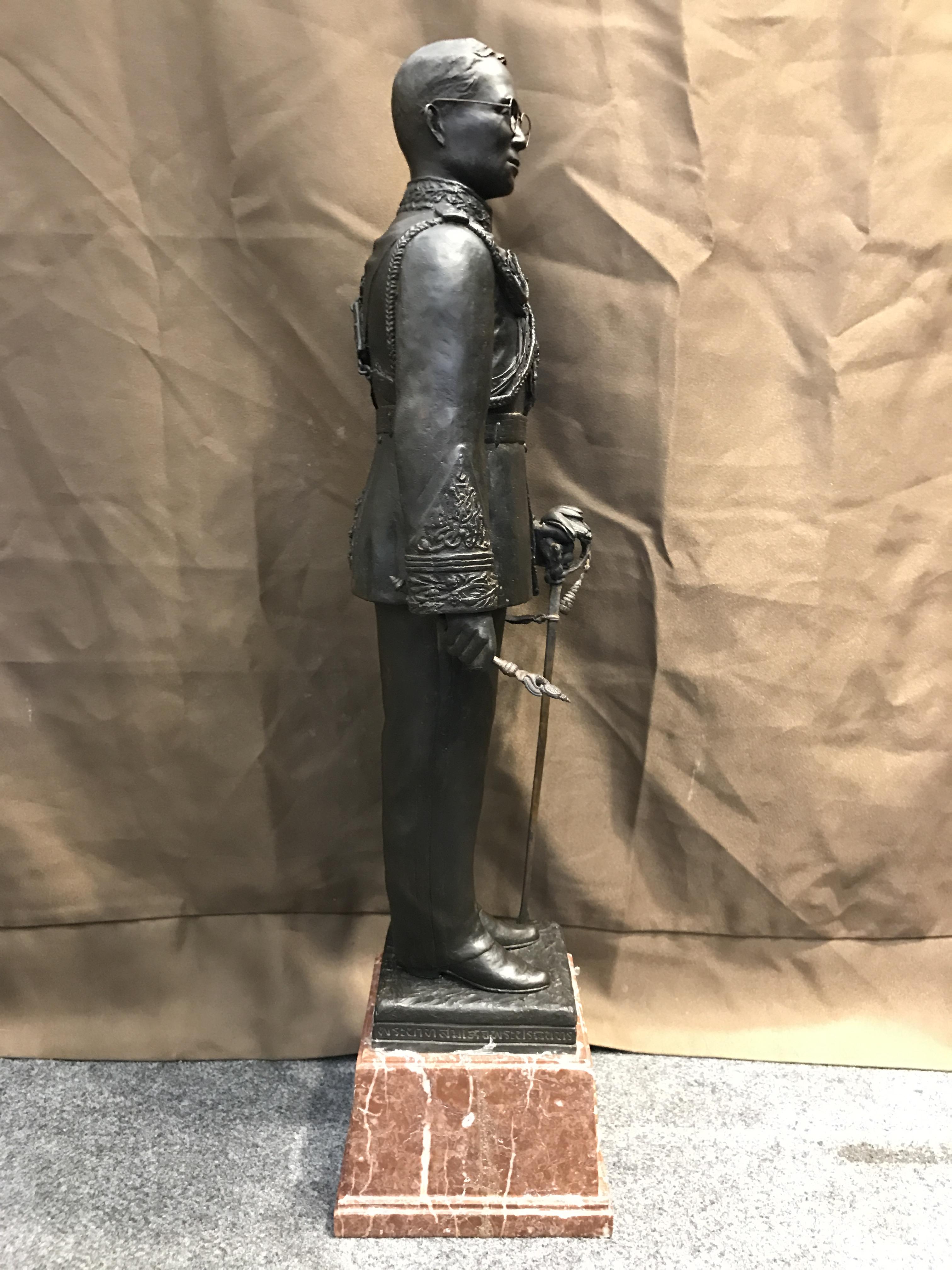 พระบรมรูปพระบาทสมเด็จพระเจ้าอยู่หัวรัชกาลที่9 เนื่องในวโรกาสที่ท่านเสด็จเถลิงถวัลย์ราชนสมบัติเป็นปีที่ 50 พุทธศักราช 2539 ( ปีกาญจนาภิเษก ) เนื้อสำริดนอก องค์ยืนบนฐานหินอ่อนพร้อมตราฉลองครองราชย์ ครบ50 ปี