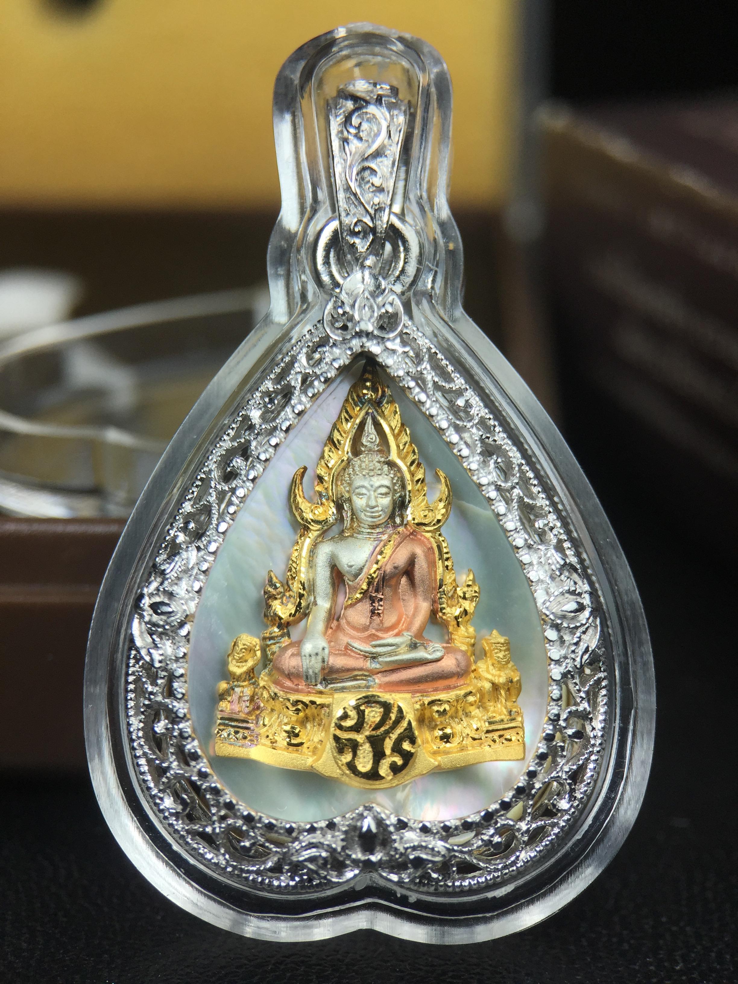 พระพุทธชินราช ภปร. โครงการ "เพราะแผ่นดินนี้ คือ แผ่นดินเกิด" ปี2548(รุ่นแรก) เหรียญทรงใบโพธิ์ ขนาด 21 x 29 มม. เนื้อเงินสามกษัตริย์ องค์พระชุบสามกษัตริย์ ล้อมด้วยกรอบเงินชุบทองคำขาวสลักเสลาเป็นลวดลายละเอียดอ่อน ส่วนพื้นองค์พระเป็นเปลือกหอยมุข