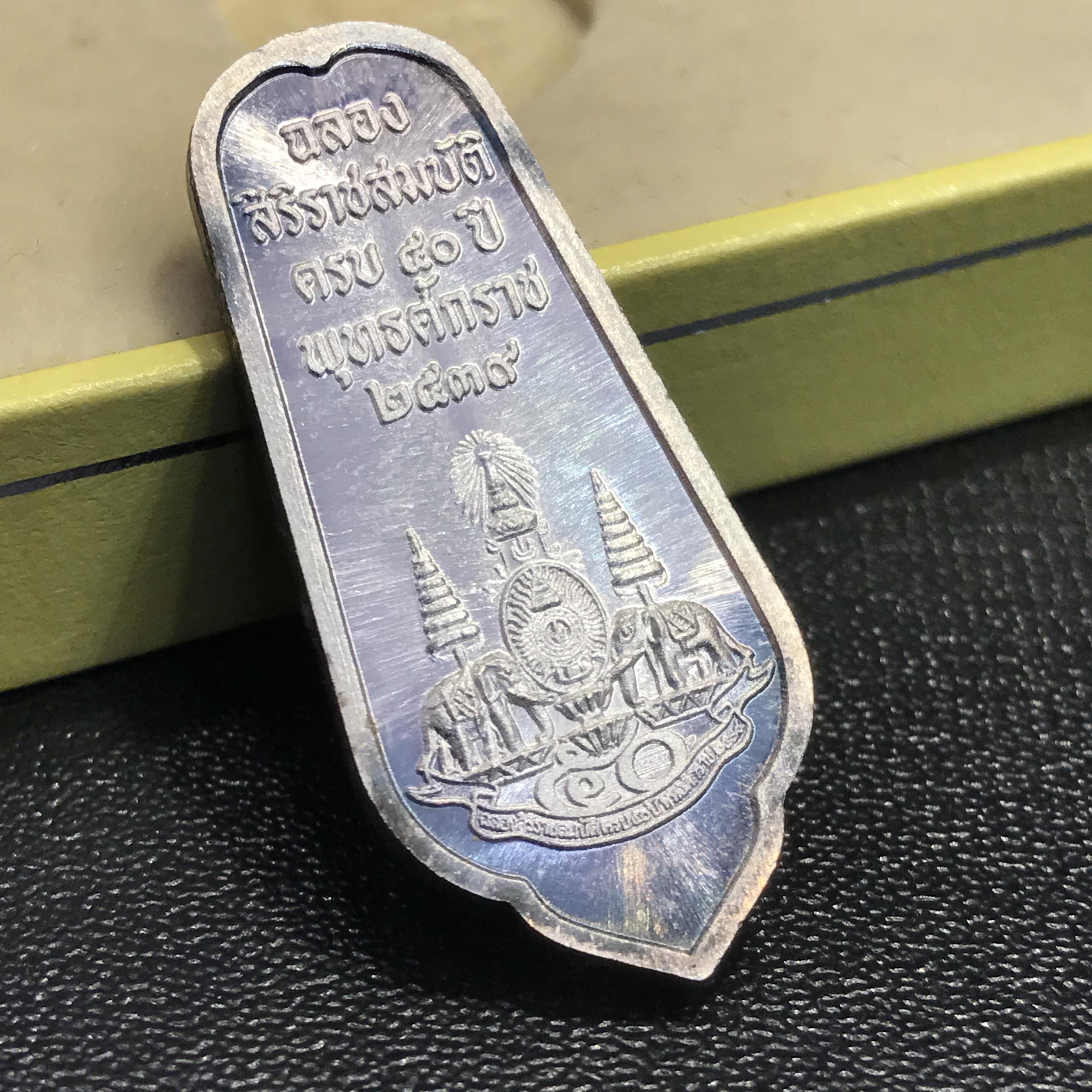 เหรียญพระพุทธอภัยมงคลสมังคี เนื้อเงิน สร้างเนื่องในมงคลโอกาสที่พระบาทสมเด็จพระเจ้าอยู่หัว ทรงครองสิริราชสมบัติครบ ๕๐ ปี พ.ศ.๒๕๓๙ ด้านหน้าประดิษฐานตราสัญลักษณ์งานฉลองสิริราชสมบัติครบ ๕๐ ปี