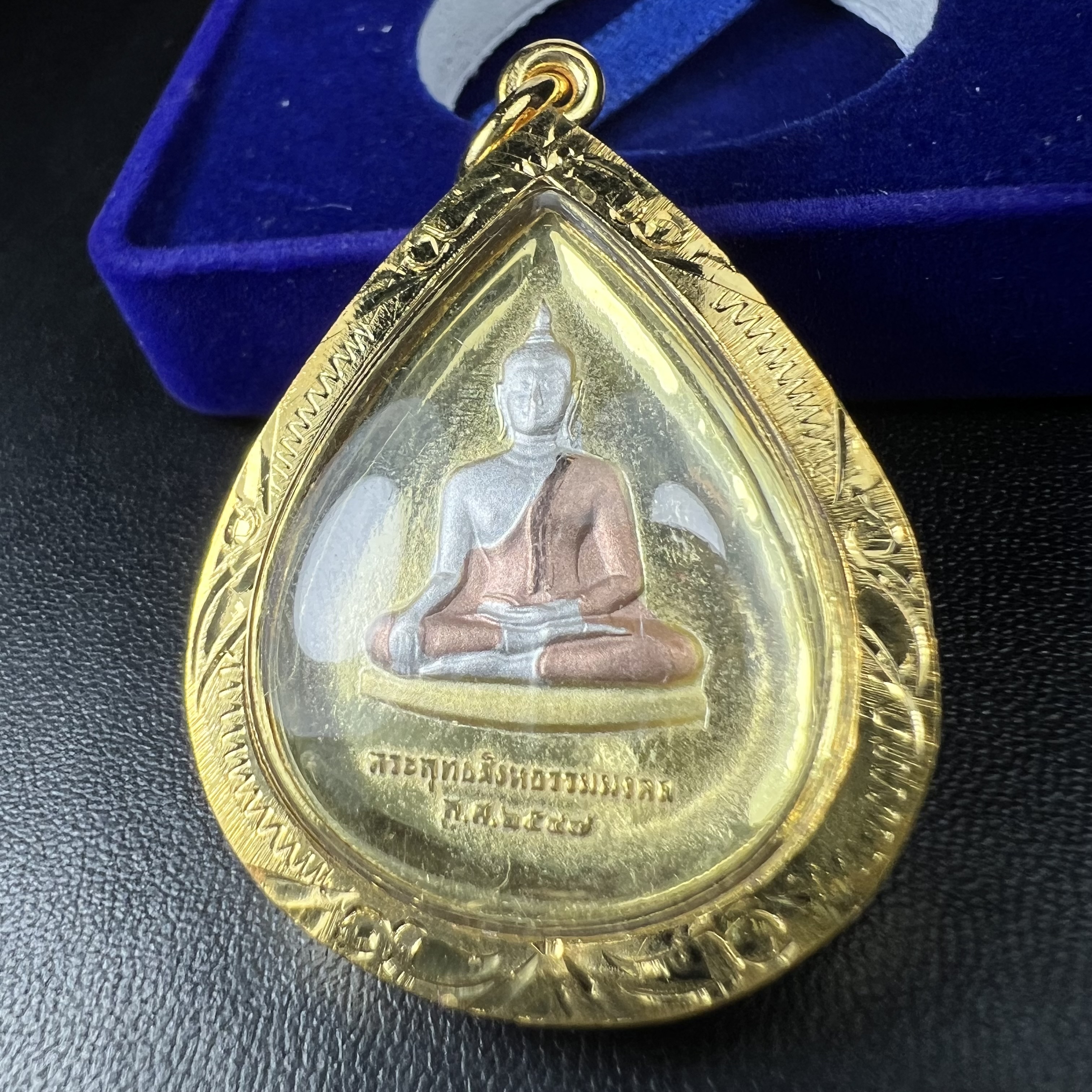 เหรียญพระพุทธสิงหธรรมมงคล ภปร. ปี 2547 ทรงหยดน้ำ ด้านหลังมี ภ.ป.ร. (ชนวนเก่า)เนื้อโลหะผสม ชุบทองสามกษัตริย์ สูง 3.3ซม.พิธีใหญ่ มวลสารดี ปลุกเสกวัดพระแก้ว(งานเลี่ยมกรอบเดิมจากผู้จัดสร้างห่อหุ้มด้วยทองนพเกล้า)