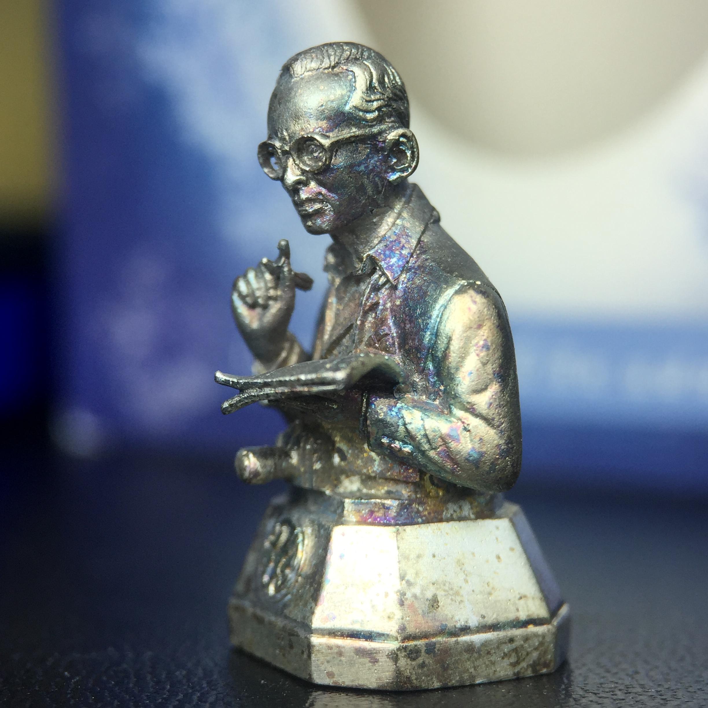 พระบรมรูปพระบาทสมเด็จพระเจ้าอยู่หัวรัชกาลที่ 9(ทรงงาน) ภปร. รุ่นเพราะแผ่นดินนี้คือแผ่นดินเกิด ปี 2551 ขนาดสูง 1 นิ้ว เนื้อเงิน(ผิวเดิมขึ้นสีรุ้งธรรมชาติสวยมาก)(ด้านหน้า ฐานพระบรมรูปฯ ประดิษฐานอักษรพระปรมาภิไธย ภ.ป.ร.)นิยมหายาก(1 ใน 5000 องค์)