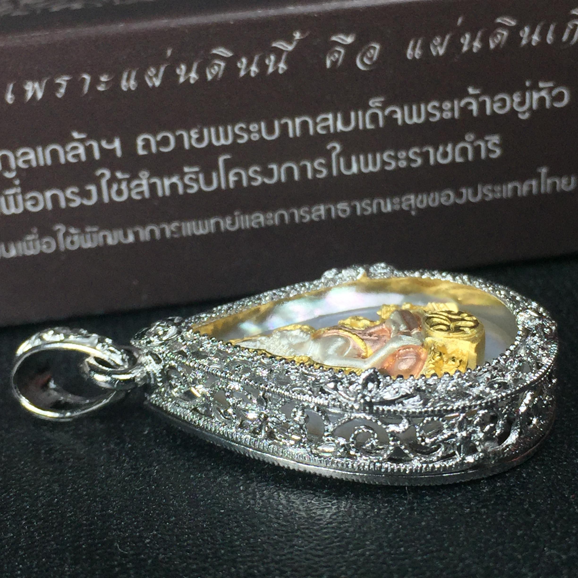 พระพุทธชินราช ภปร. โครงการ "เพราะแผ่นดินนี้ คือ แผ่นดินเกิด" ปี2548(รุ่นแรก) เหรียญทรงหยดน้ำ ขนาด 21 x 31 มม. เนื้อเงินสามกษัตริย์ องค์พระชุบสามกษัตริย์ ล้อมด้วยกรอบเงินชุบทองคำขาวสลักเสลาเป็นลวดลายละเอียดอ่อน ส่วนพื้นองค์พระเป็นเปลือกหอยมุข