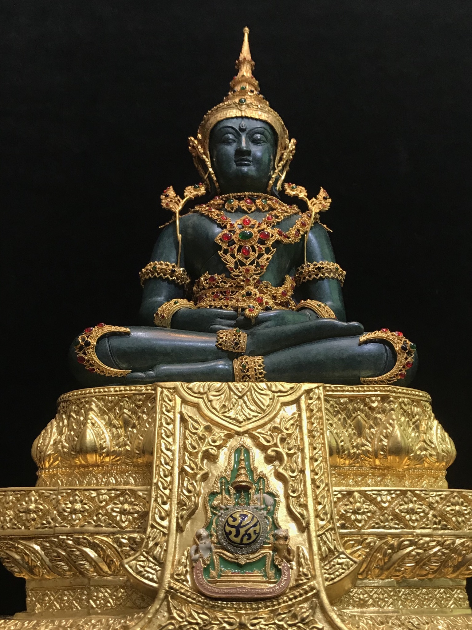 พระแก้วมรกต(จำลอง)ลอยองค์ ขนาดหน้าตัก 5 นิ้ว ทรงเครื่องฤดูร้อน เนื้อโลหะเคลือบสีเขียว เครื่องทรงชุบทองลงยาสี ฐานเนื้อโลหะ ลงรักปิดทองคำ ประดิษฐานตราสัญลักษณ์ฉลองสิริราชสมบัติ ครบ 60 ปี