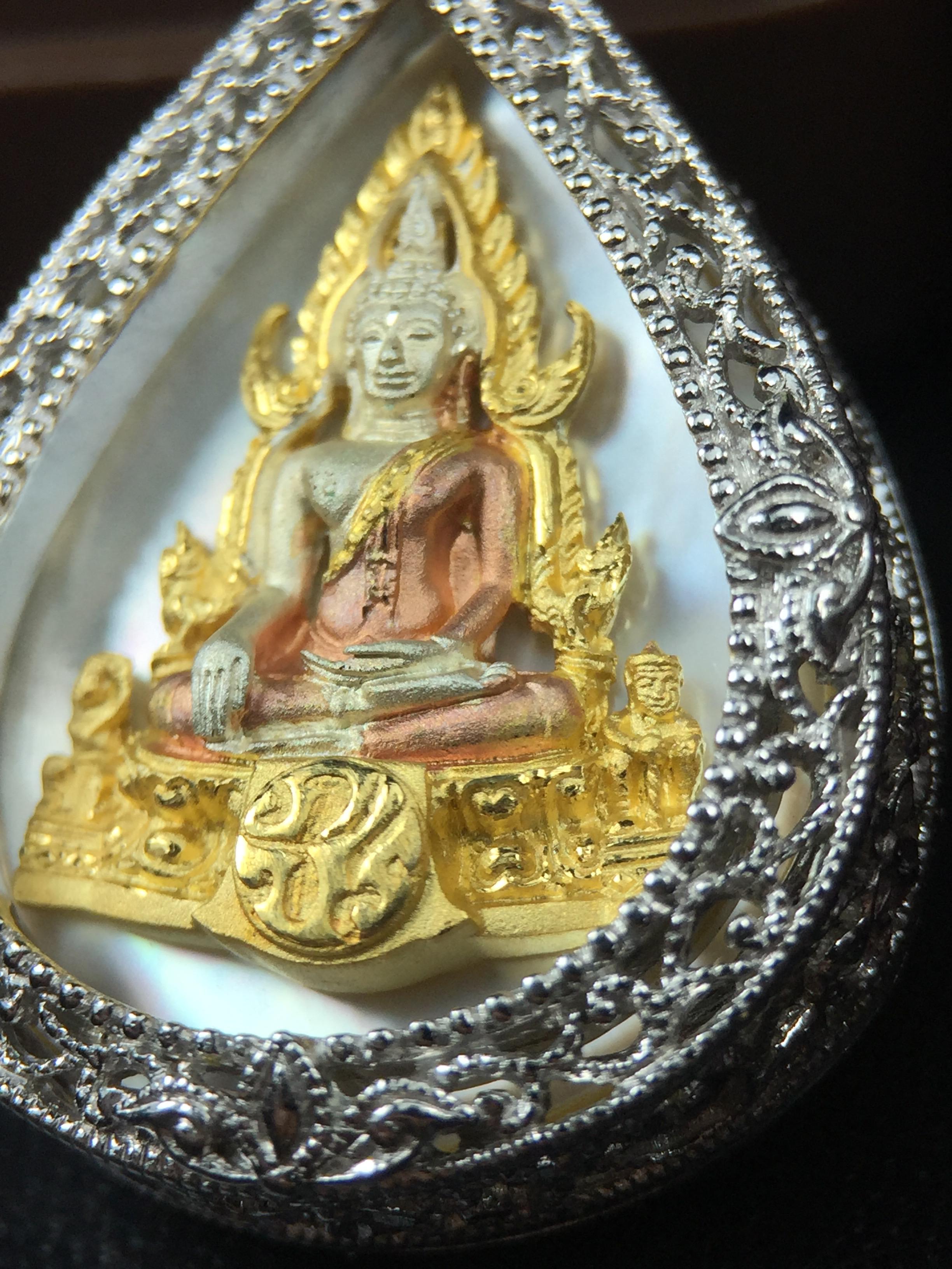 พระพุทธชินราช ภปร. โครงการ "เพราะแผ่นดินนี้ คือ แผ่นดินเกิด" ปี2548(รุ่นแรก) เหรียญทรงหยดน้ำ ขนาด 21 x 31 มม. เนื้อเงินสามกษัตริย์ องค์พระชุบสามกษัตริย์ ล้อมด้วยกรอบเงินชุบทองคำขาวสลักเสลาเป็นลวดลายละเอียดอ่อน ส่วนพื้นองค์พระเป็นเปลือกหอยมุข