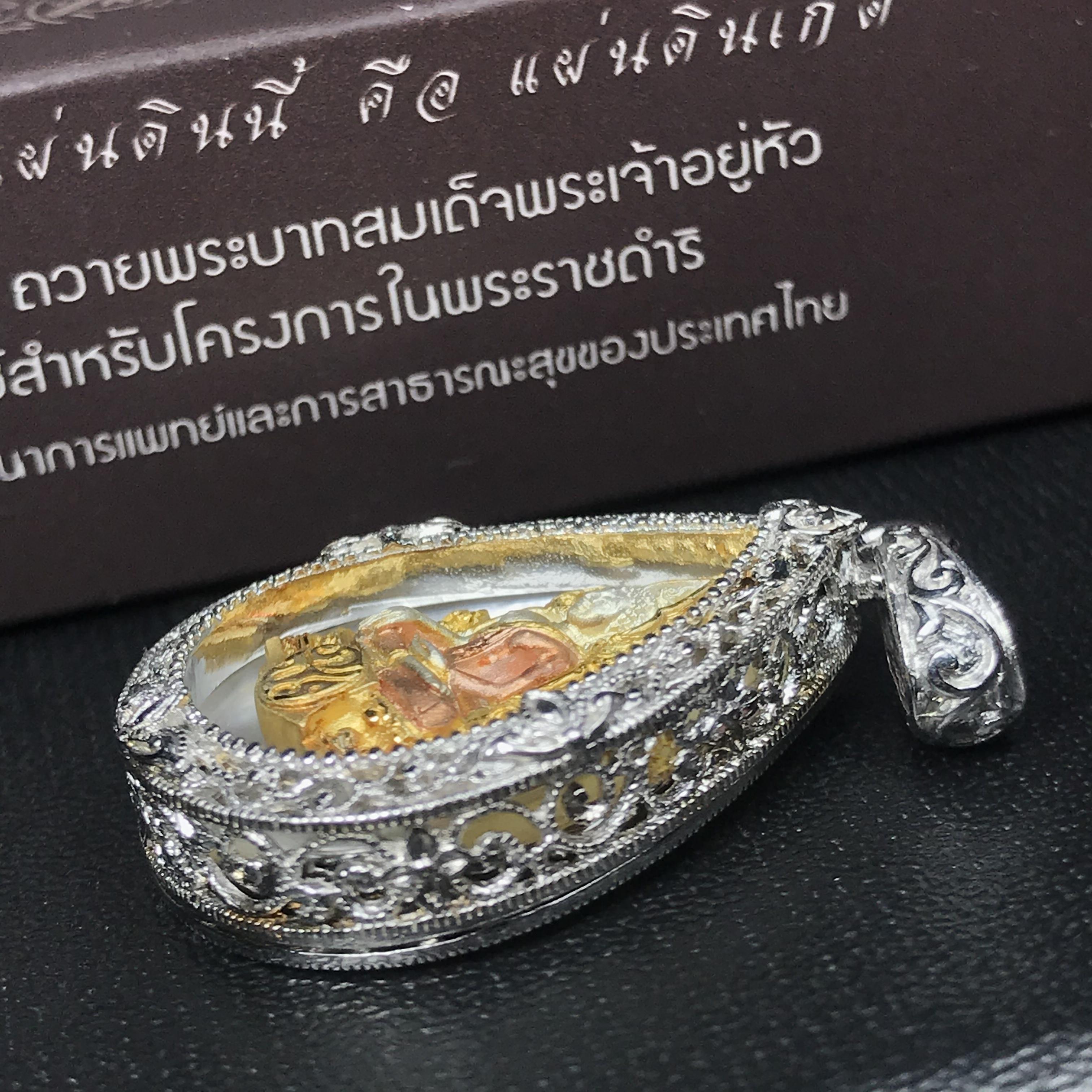 พระพุทธชินราช ภปร. โครงการ "เพราะแผ่นดินนี้ คือ แผ่นดินเกิด" ปี2548(รุ่นแรก) เหรียญทรงหยดน้ำ ขนาด 21 x 31 มม. เนื้อเงินสามกษัตริย์ องค์พระชุบสามกษัตริย์ ล้อมด้วยกรอบเงินชุบทองคำขาวสลักเสลาเป็นลวดลายละเอียดอ่อน ส่วนพื้นองค์พระเป็นเปลือกหอยมุข