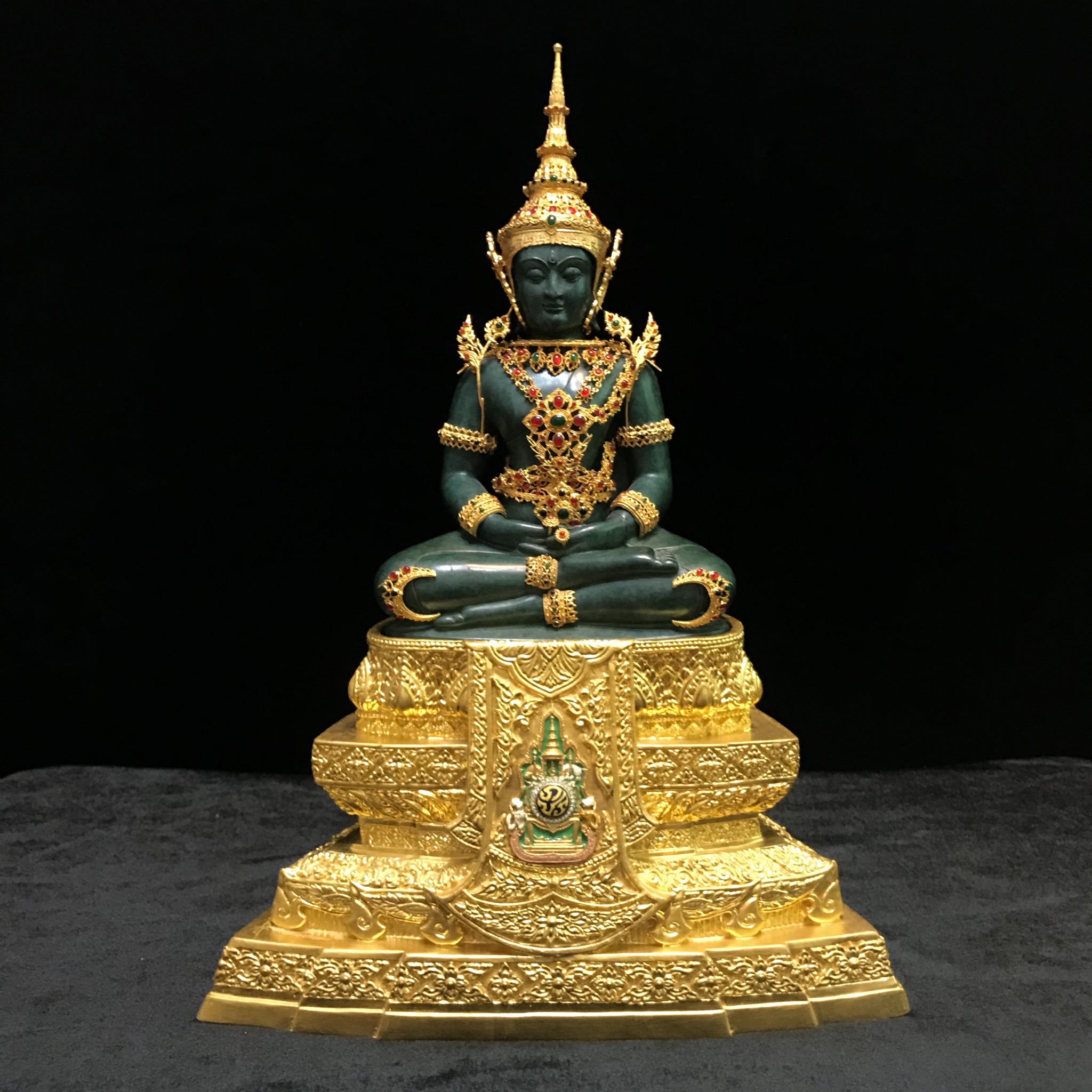 พระแก้วมรกต(จำลอง)ลอยองค์ ขนาดหน้าตัก 5 นิ้ว ทรงเครื่องฤดูร้อน เนื้อโลหะเคลือบสีเขียว เครื่องทรงชุบทองลงยาสี ฐานเนื้อโลหะ ลงรักปิดทองคำ ประดิษฐานตราสัญลักษณ์ฉลองสิริราชสมบัติ ครบ 60 ปี