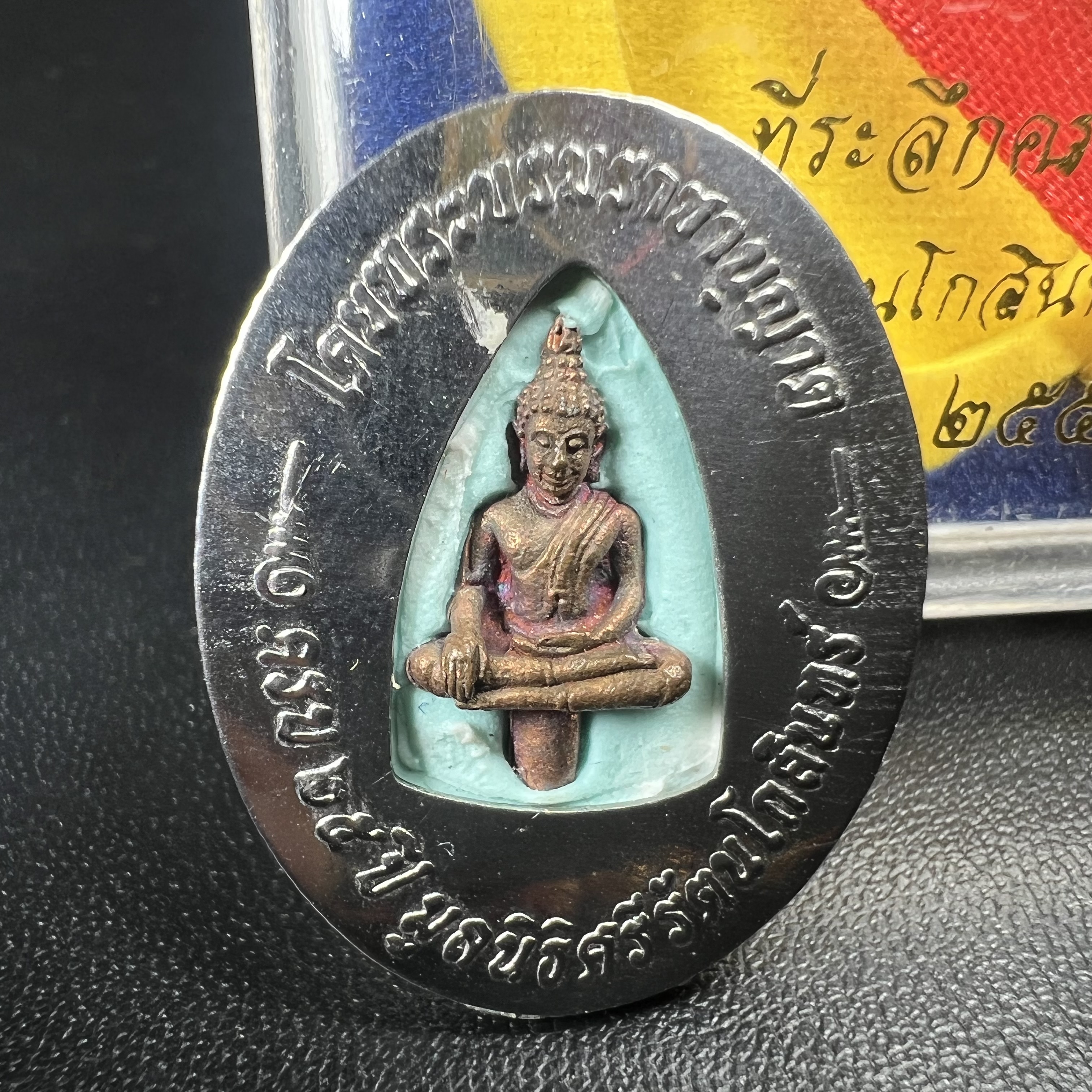 ล็อกเกตในหลวงรัชกาลที่9 ที่ระลึกครบ 25 ปี มูลนิธิศรีรัตนโกสินทร์ วัดสุทธาราม พ.ศ. 2550 พิมพ์ทรงวงรีรูปไข่เล็กฉากสีทอง หลังปิดแผ่นโลหะสีขาว(สแตนเลส)ฝังพระยอดธง(นิยม)